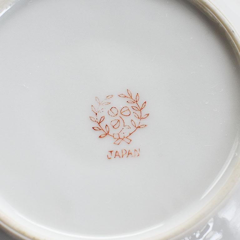 A small gold ceramic ashtray or vide poche with a bird motif. A lovely decorative trinket dish or ashtray that will be gorgeous on a side table or dressing table. The porcelain dish is round and hand-painted with a metallic gold border on a crisp