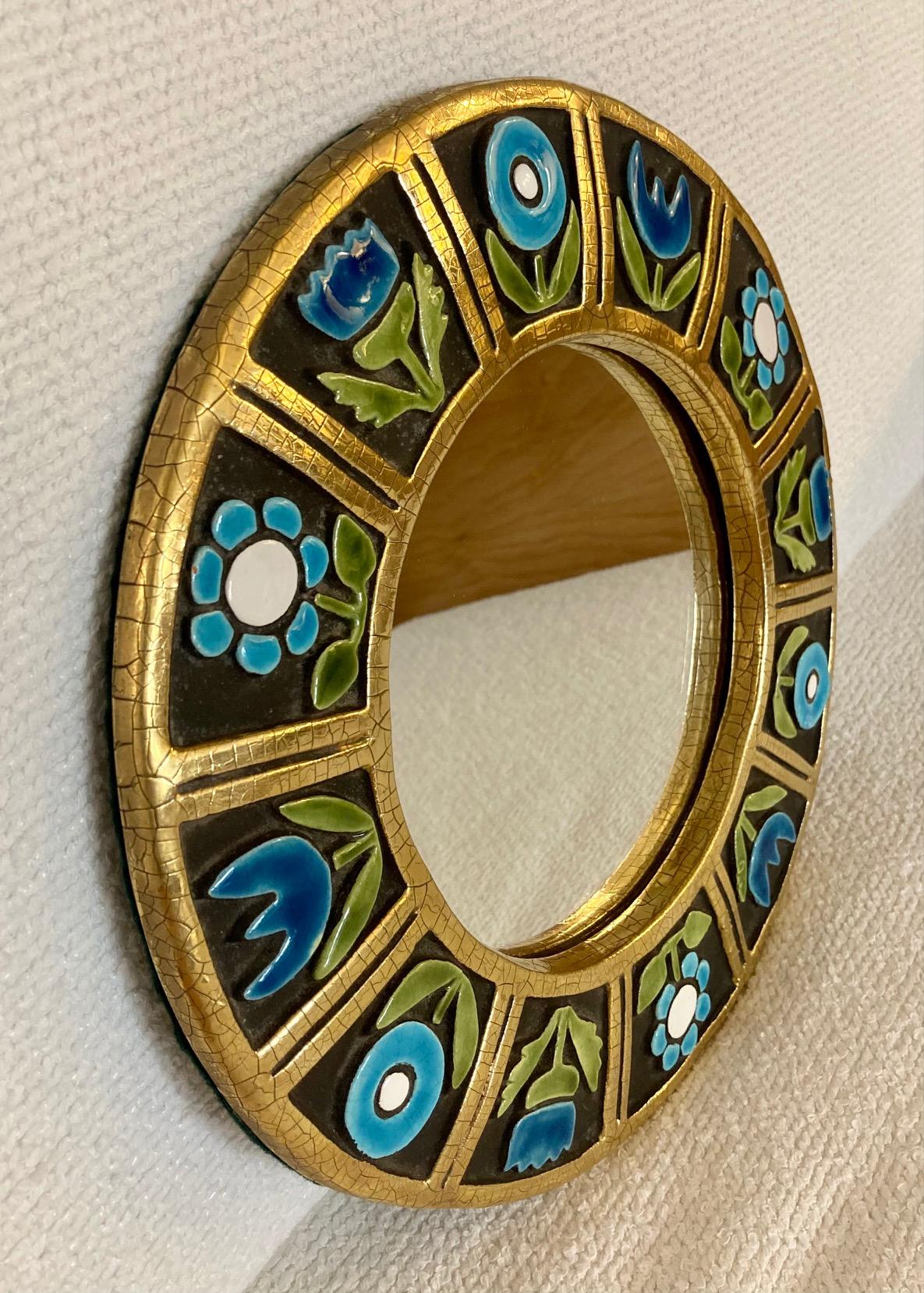 Round ceramic wall mirror.

The mirror is decorated with a frieze of blue flowers with gold enameled frame and edge.

Original green felt at the back, with ware in the corners 

Mithé Espelt (born 1923)

Lunel, south of France,

circa