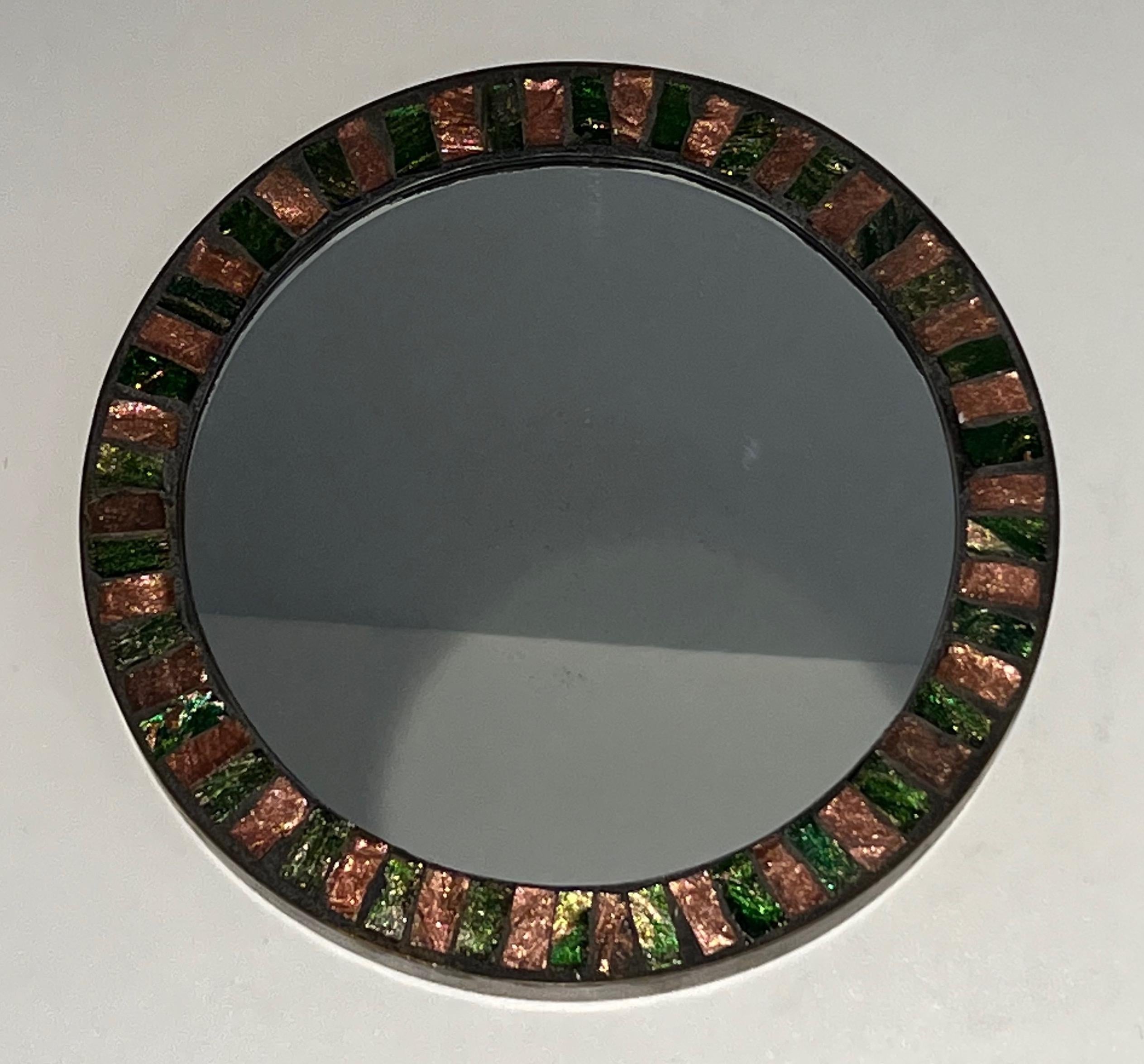 This very nice round mirror is made of a glazed ceramic surrounded by a brass band. This is a French work. Circa 1950