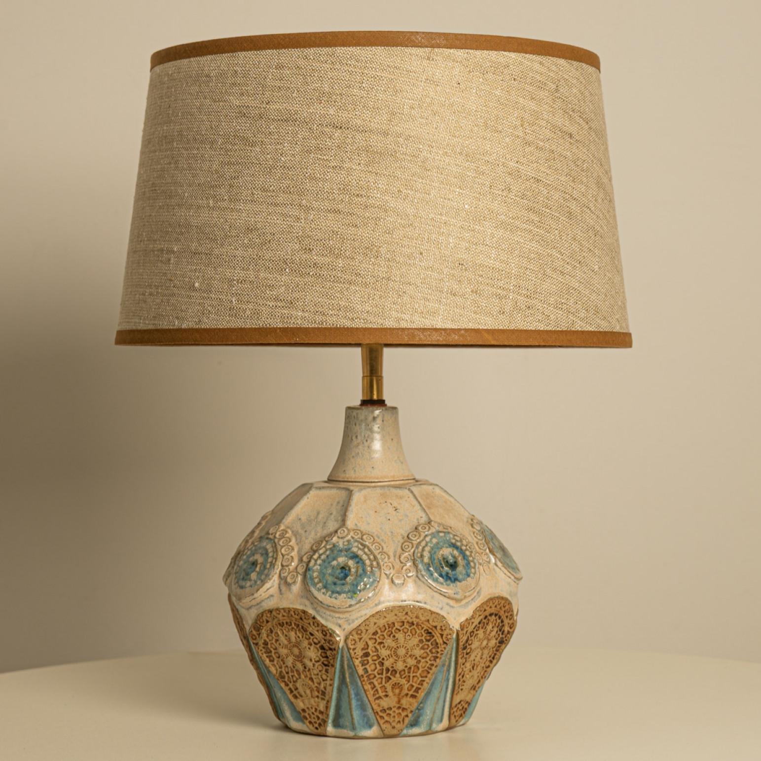 A beige ceramic table lamp with blue and brown accents. Sculptural piece, made of handmade ceramic in fresh tones, with a new custom made matching silk lampshade by René Houben.

The lamp is in perfect vintage condition. The lamp is offered with new