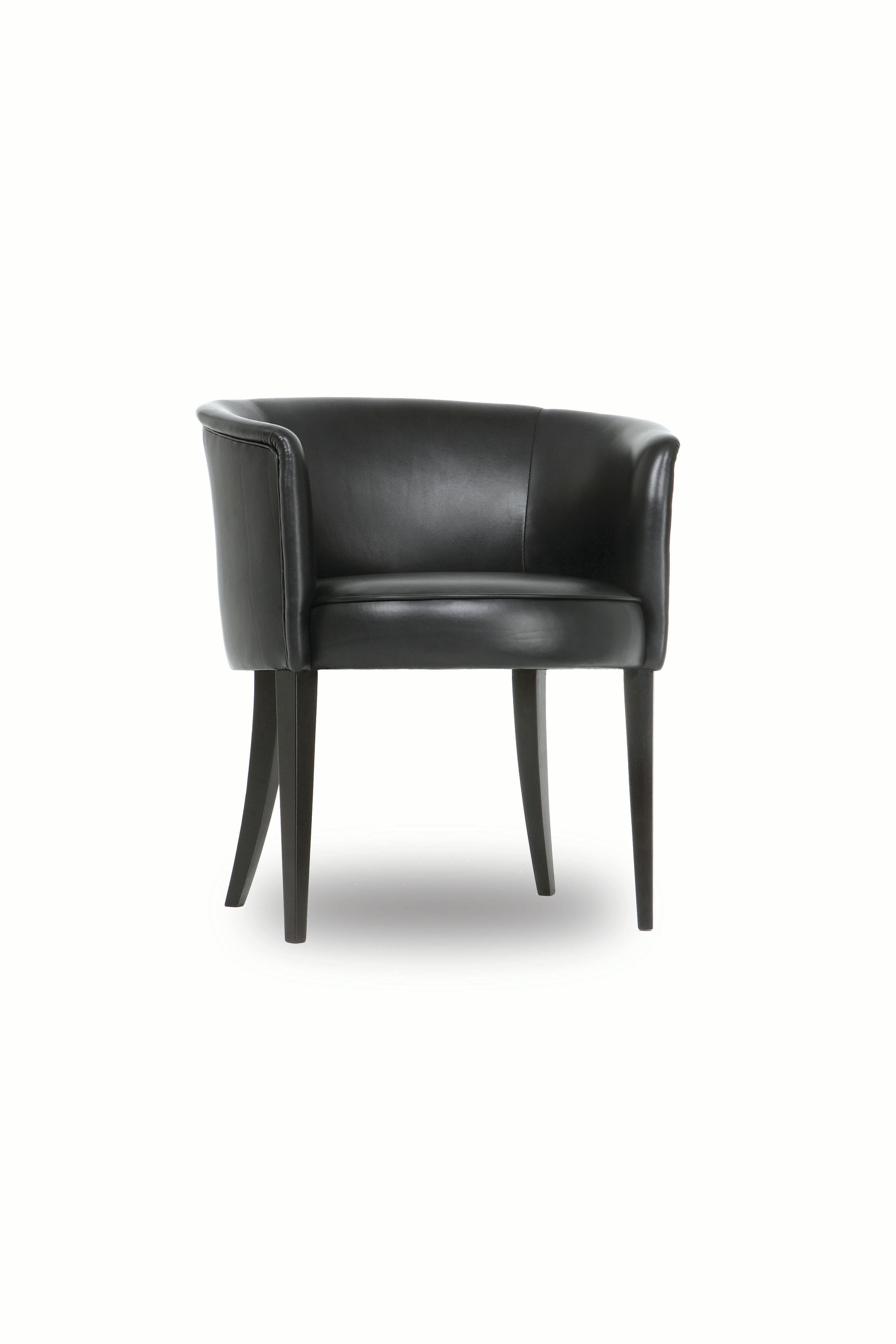 The Round chair has a tight upholstered seat and back. Seams are finished with self welts. Tapered front legs and curved back legs are made of blackened hardwood. 

This is a showroom sample upholstered in dark brown leather.
 