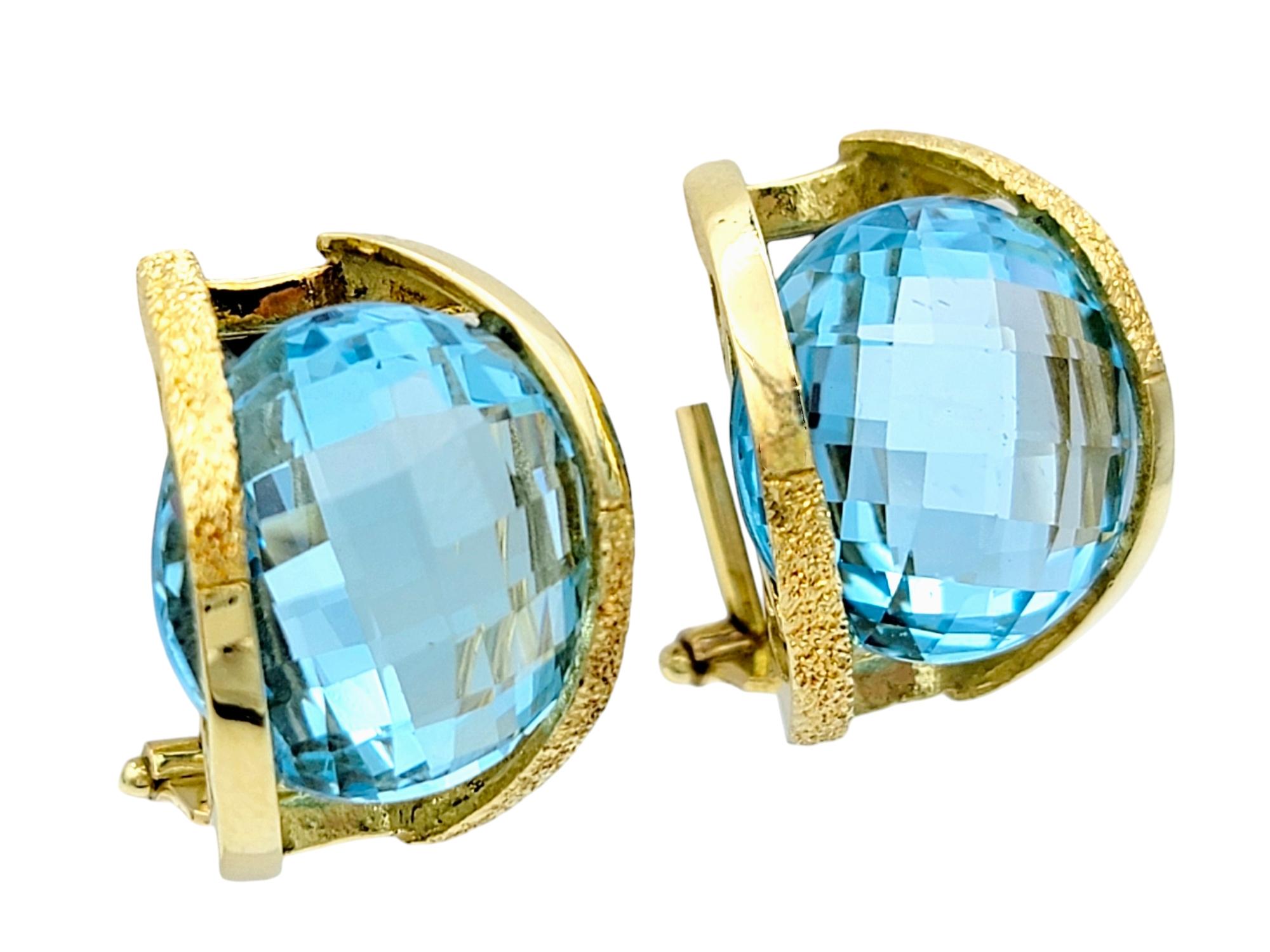 Contemporary Round Checkerboard Cut Blue Topaz Omega Back Earrings in 18 Karat Yellow Gold For Sale