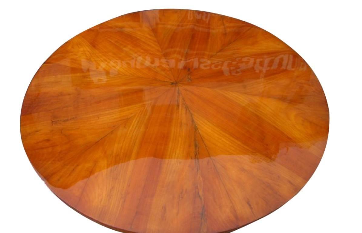 A round Biedermeier table veneered with cherrywood. This piece was manufactured around 1830 in the famous Biedermeier period, and is in a very good condition. The leg is made of massive cherry wood which allows the piece to stand very sturdy without