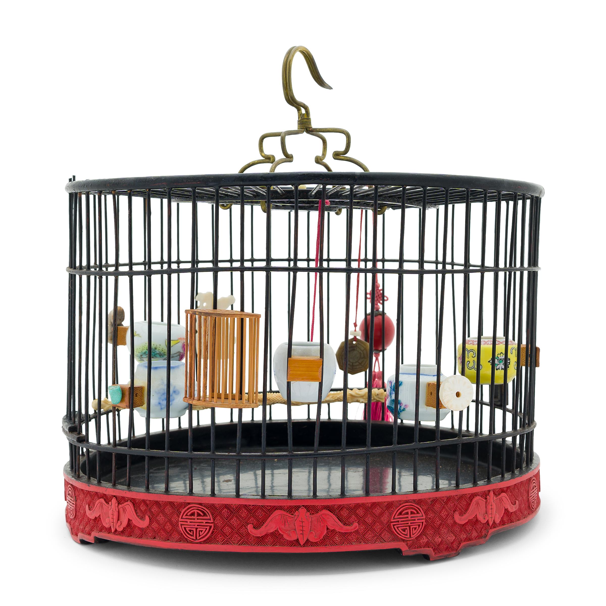 This delicate birdcage was once home to the tiny pet bird of a Qing-dynasty aristocrat. Dated to the late 19th century, the round cage has a cylindrical form carefully assembled from thin bamboo rods finished with black lacquer. The base is