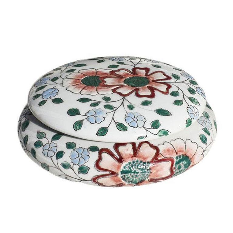 A round ceramic chinoiserie flower motif lidded box. This beautiful piece will be fantastic on a nightstand or coffee table. The top and sides are painted with rich pink and red flowers, with green climbing leaves. 

Dimensions:
6.5