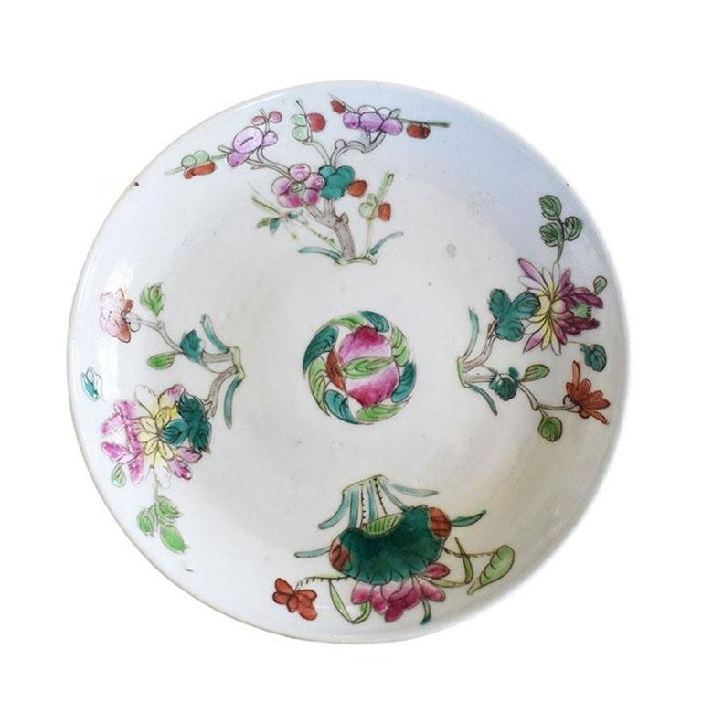 A petite famille rose catchall trinket dish hand painted with pink and green floral motifs. Round in form, this small decorative ceramic dish will be a fabulous touch to a coffee table, nightstand, or foyer table. It is in a crisp white, and