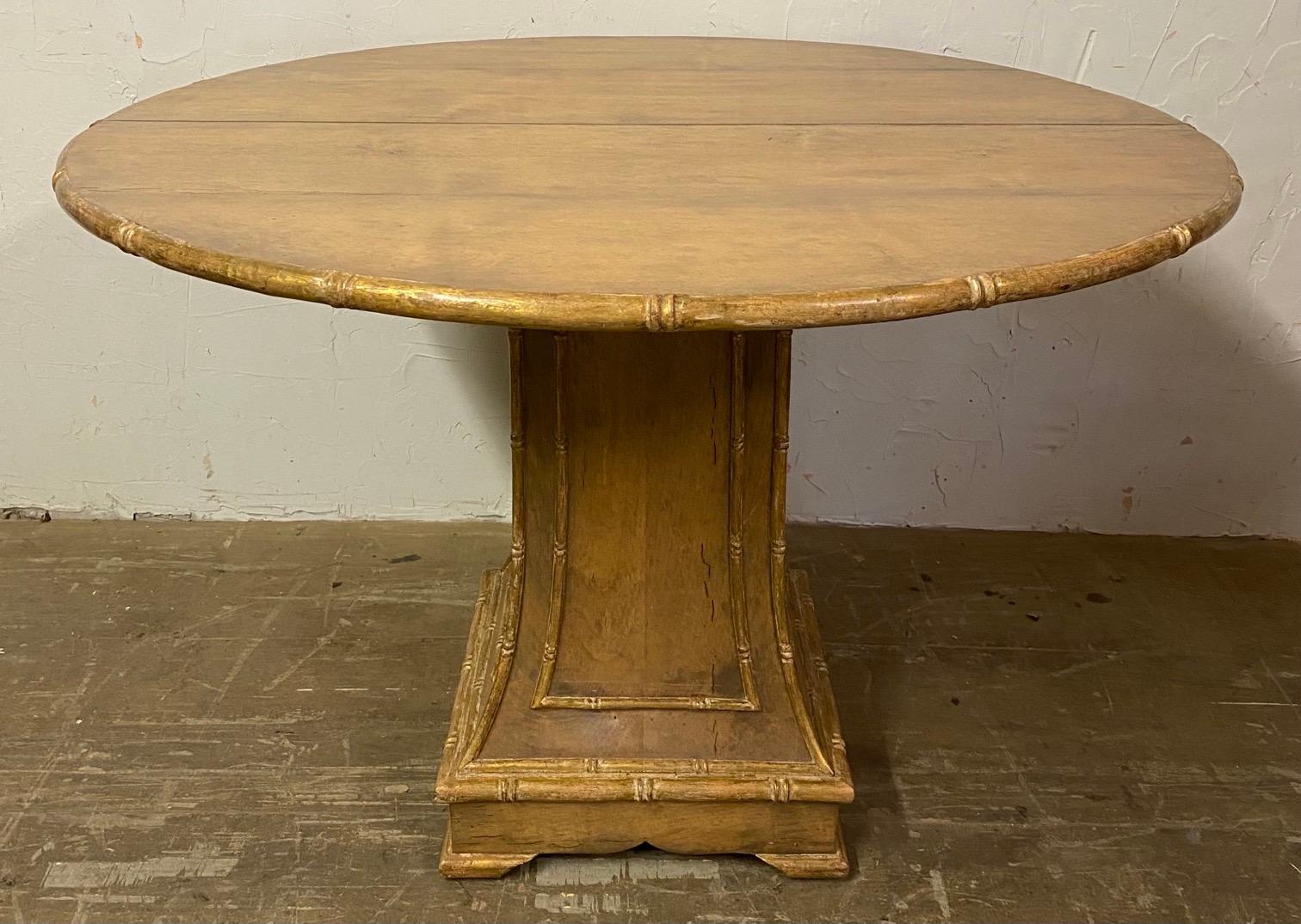 Wonderfully stylish round pedestal table with gold gilt edging and supporting column decorated with carved faux bamboo detailing. Paint has worn to a degree giving it wonderful patina which gives it added casual charm and elegance.
Table can make a