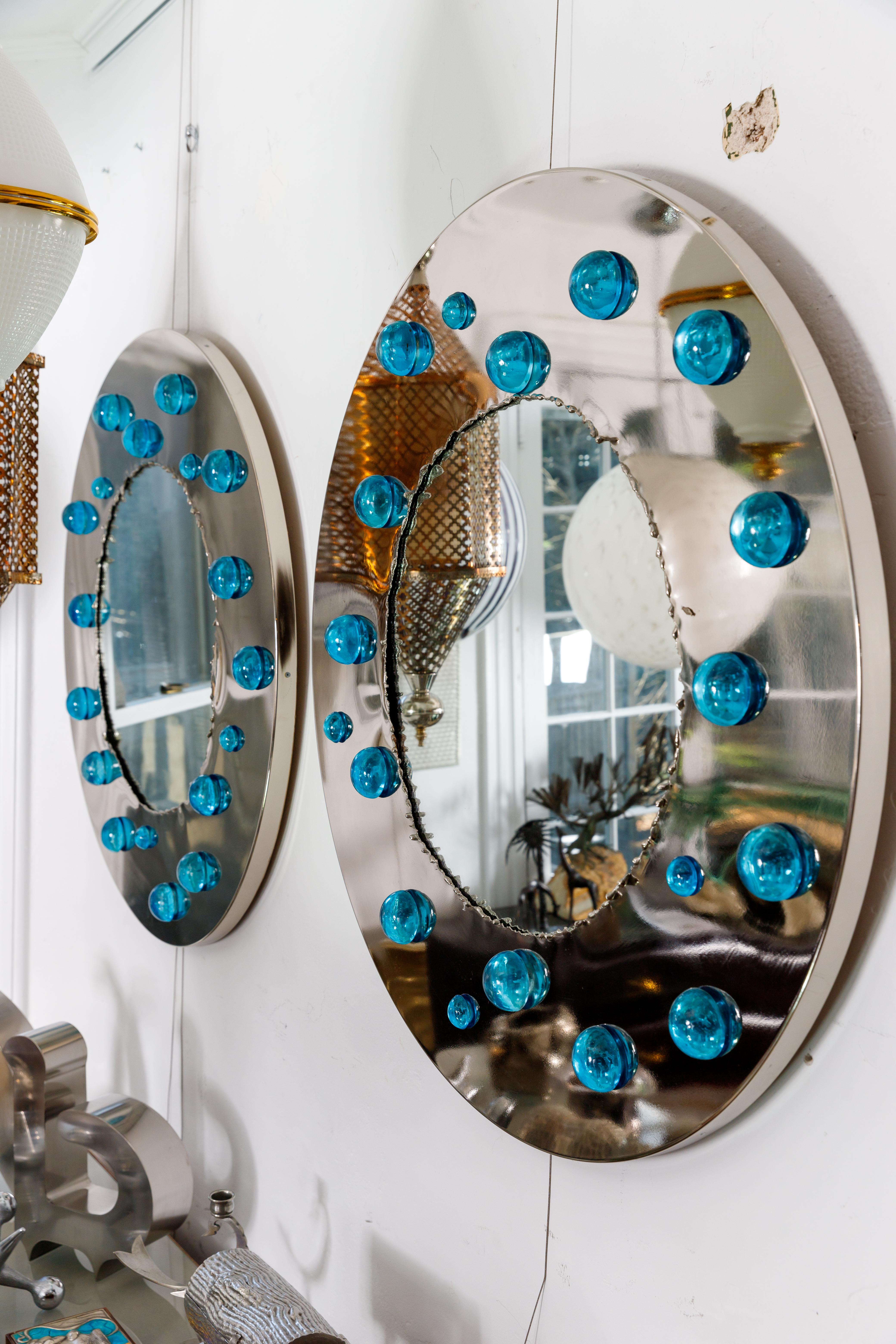Round chrome surround mirror with blue dot glass appliques.