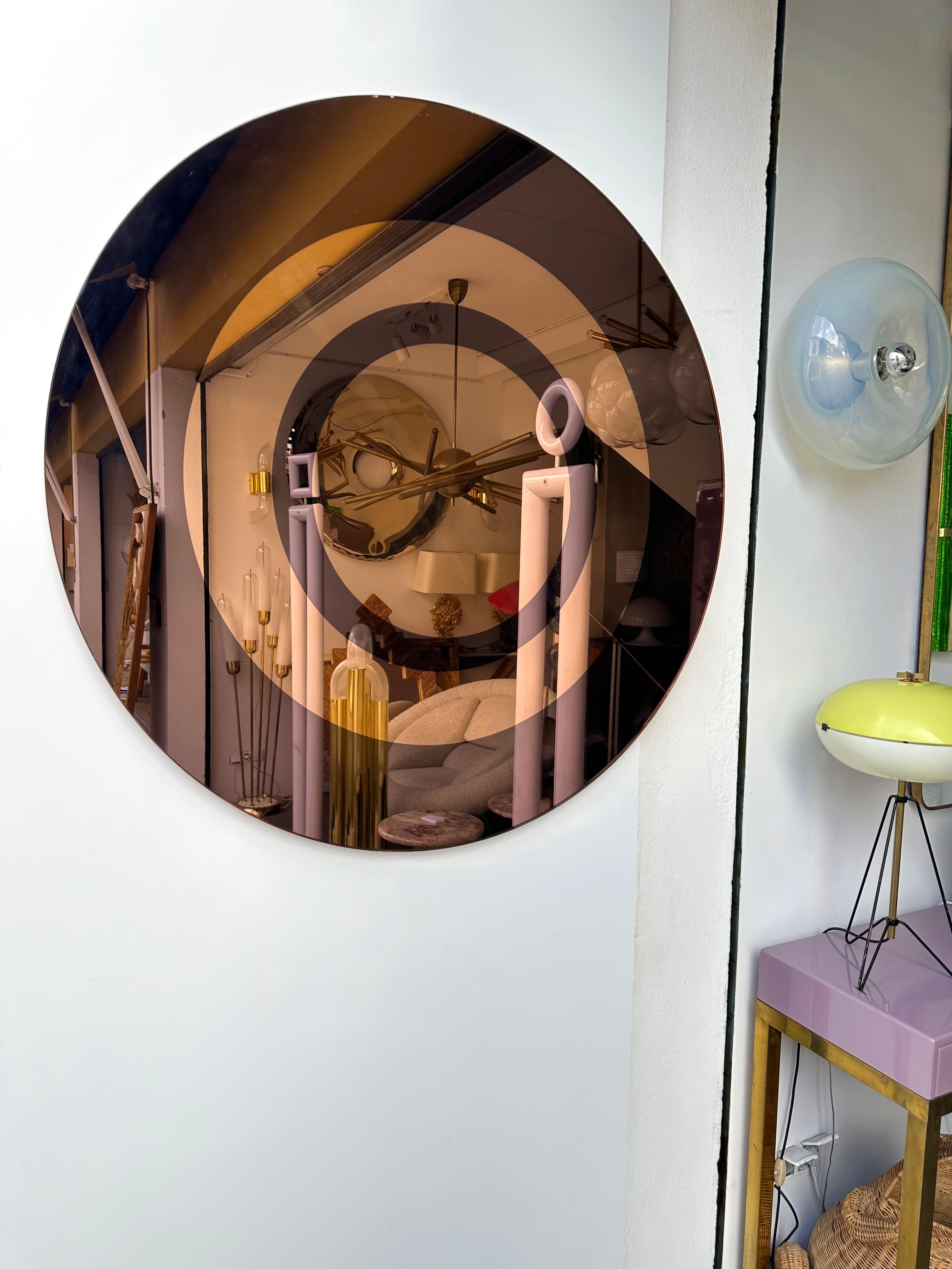 Rare miroir mural circulaire de la manufacture de design italienne Cristal Art à Turin. Verre de couleur brun fumé, cuivre doré. Cette pièce est référencée dans le livre Cristal Art. Une fabrication célèbre comme Fontana Arte.