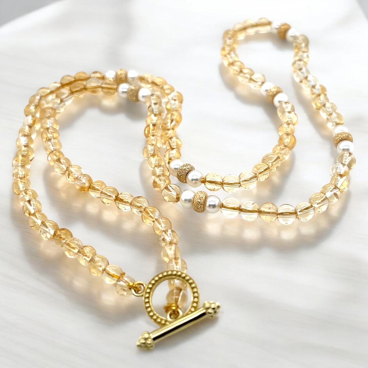 Ce joli collier réunit des citrines dorées, des perles blanches lumineuses et de l'or jaune riche dans une merveilleuse combinaison qui est parfaite pour le jour comme pour le soir.  Les perles rondes de 4 mm accentuent le collier et offrent un