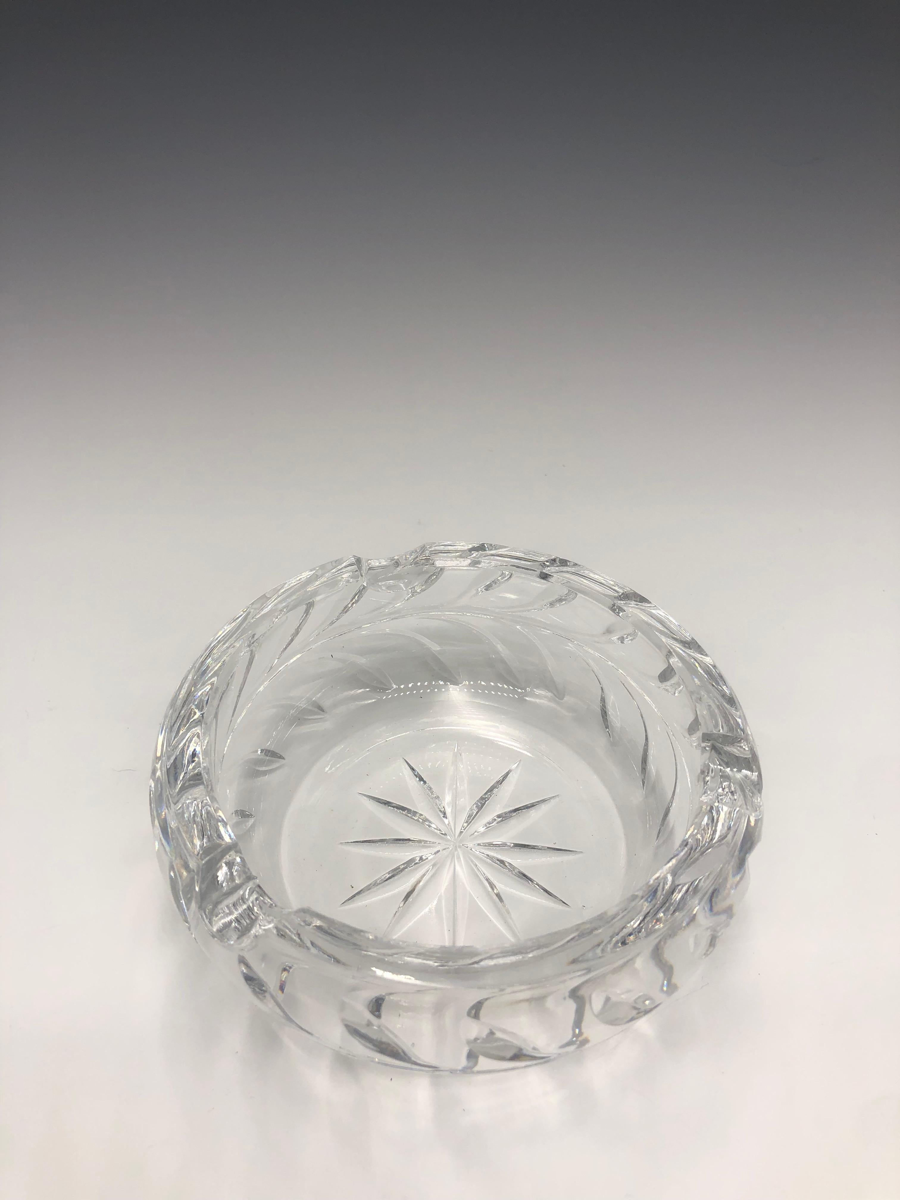 Cendrier en verre clair, épais, non marqué, rond et taillé dans le cristal, en parfait état. 

Il est orné d'un motif étoilé et ensoleillé au centre et d'un motif en forme de feuille sur le pourtour. 

Une jolie pièce décorative de table qui peut