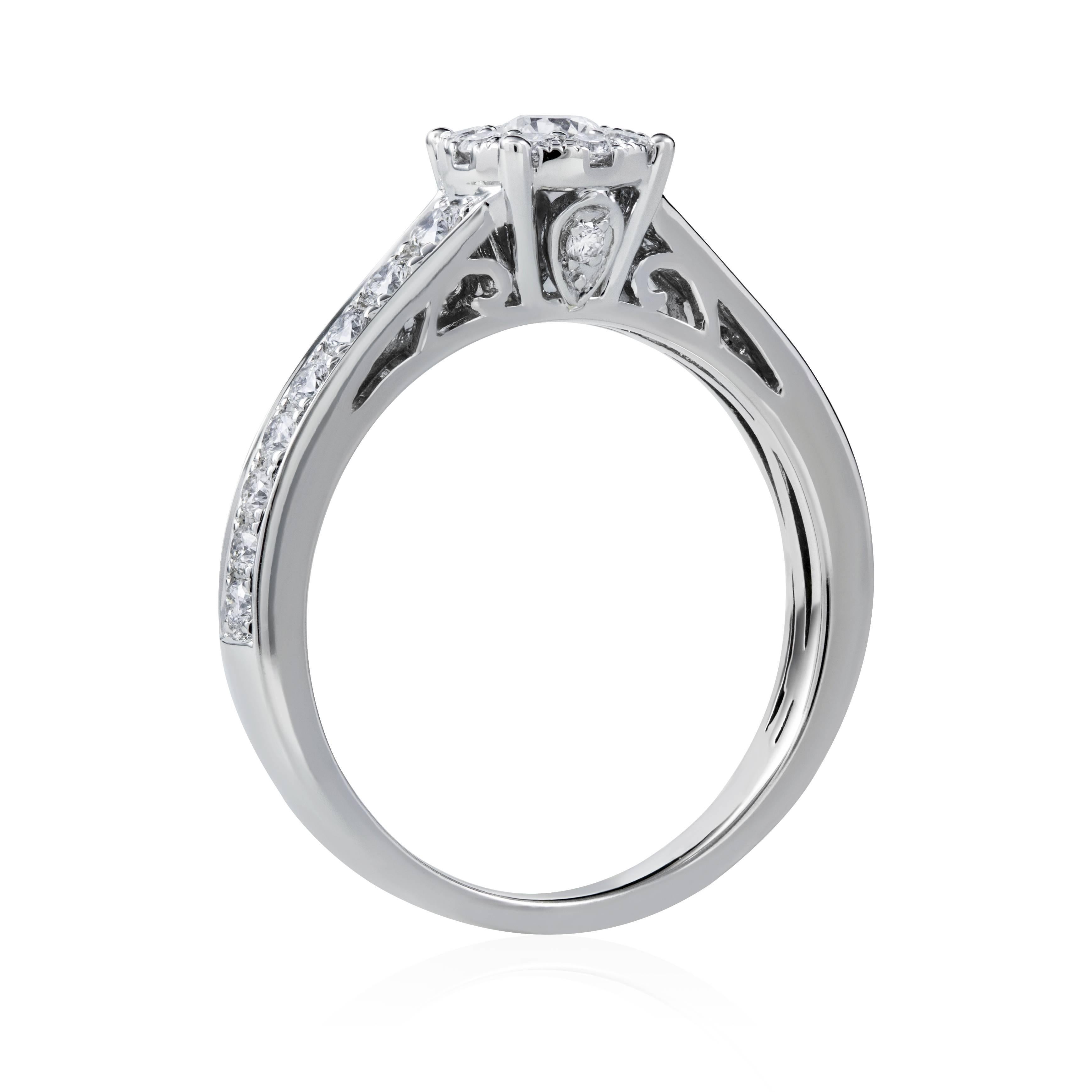 This Round Cluster Diamond Engagement Ring in 18K white gold showcases 0.67 carats of sparkling round diamonds. Featuring a round solitaire illusion design accented with graduating round diamond side stones,  this ladies diamond ring makes an