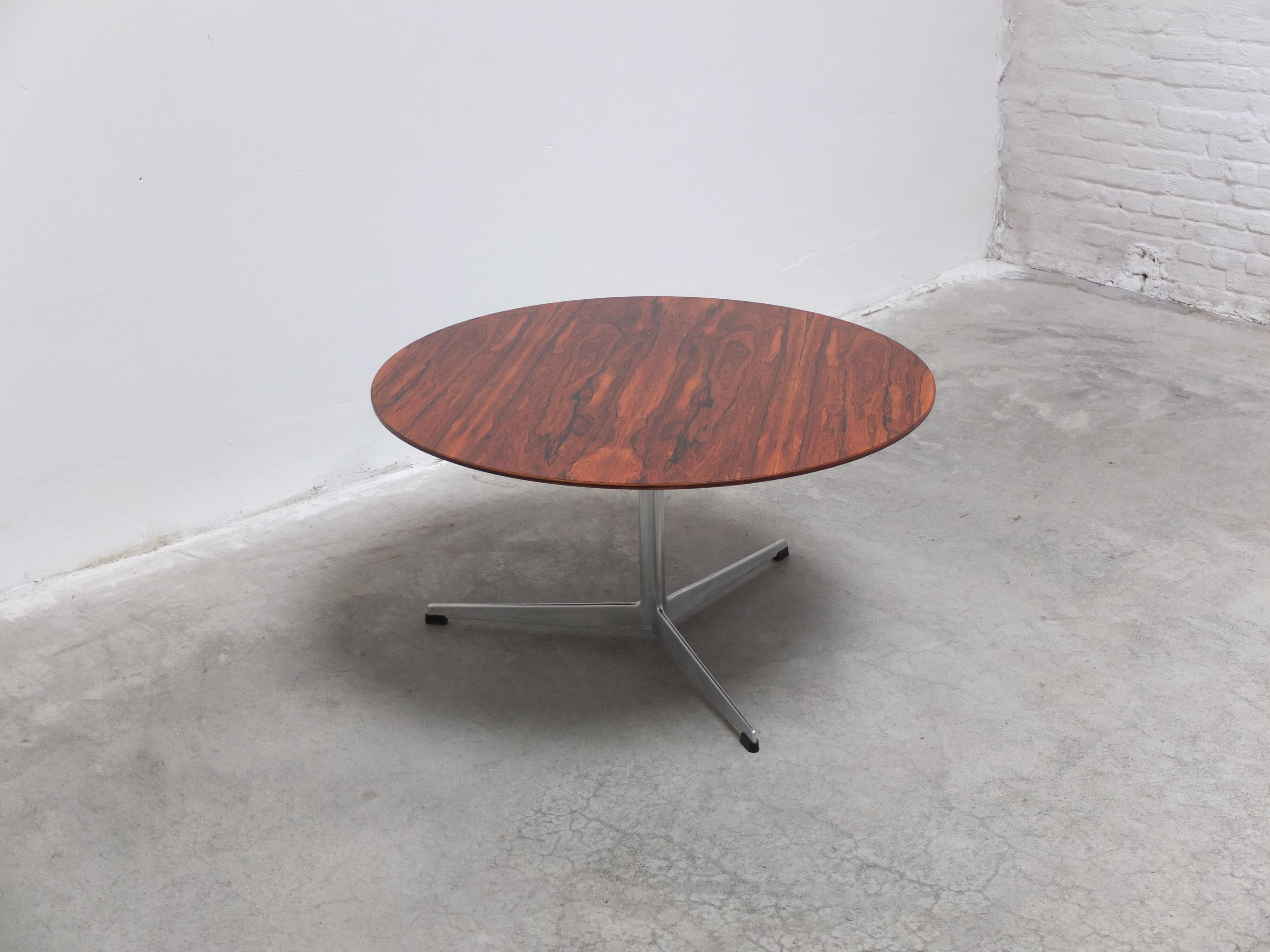 Rare coffee table designed by Arne Jacobsen the 1960s. The round top has an exceptional decorative wood drawing. It rests on the signature aluminum central base with 3 legs. Produced in Denmark by Fritz Hansen in 1965 (labeled). Hard to find