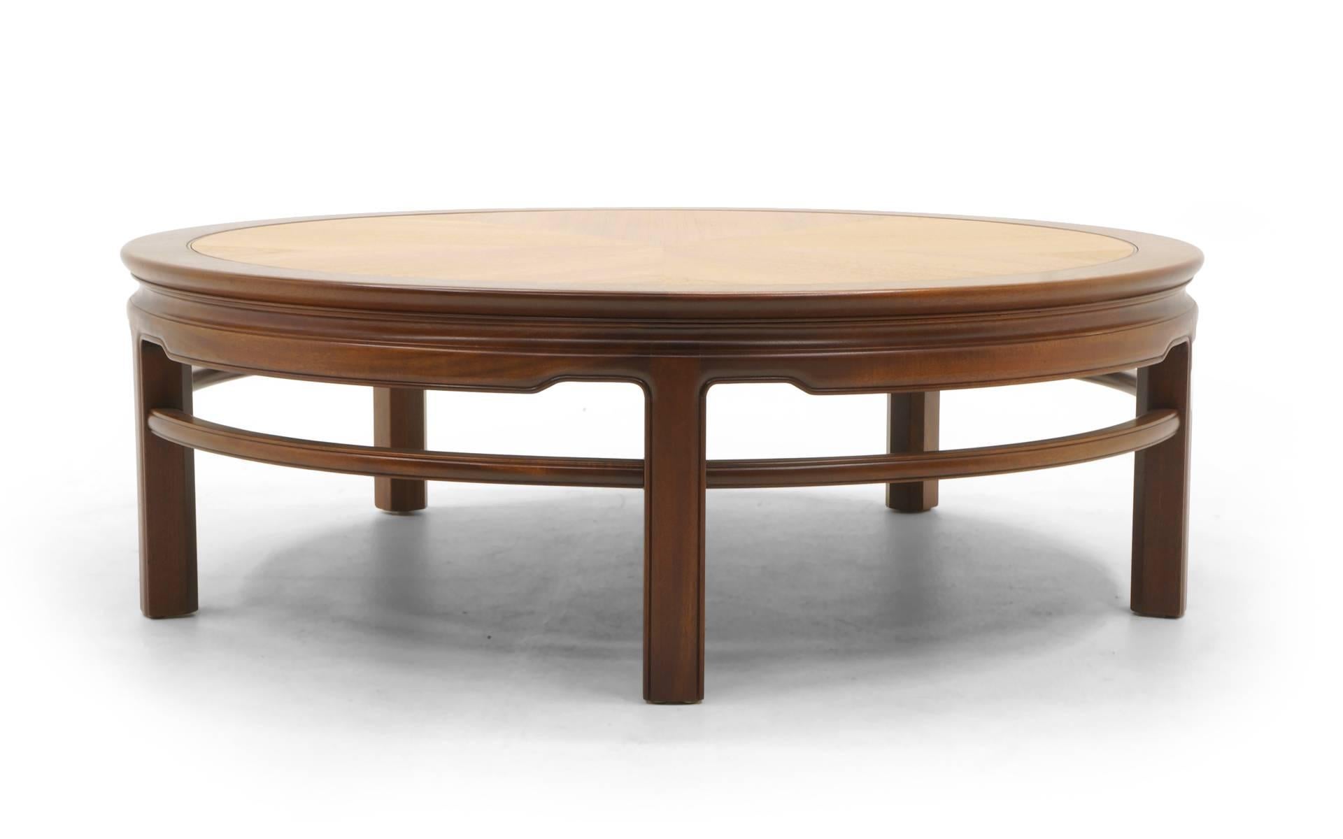 Round coffee/cocktail table manufactured by Kittinger, 1950s. Expertly restored teak top with mahogany trim, legs and stretchers. Asian inspired design. High quality construction.