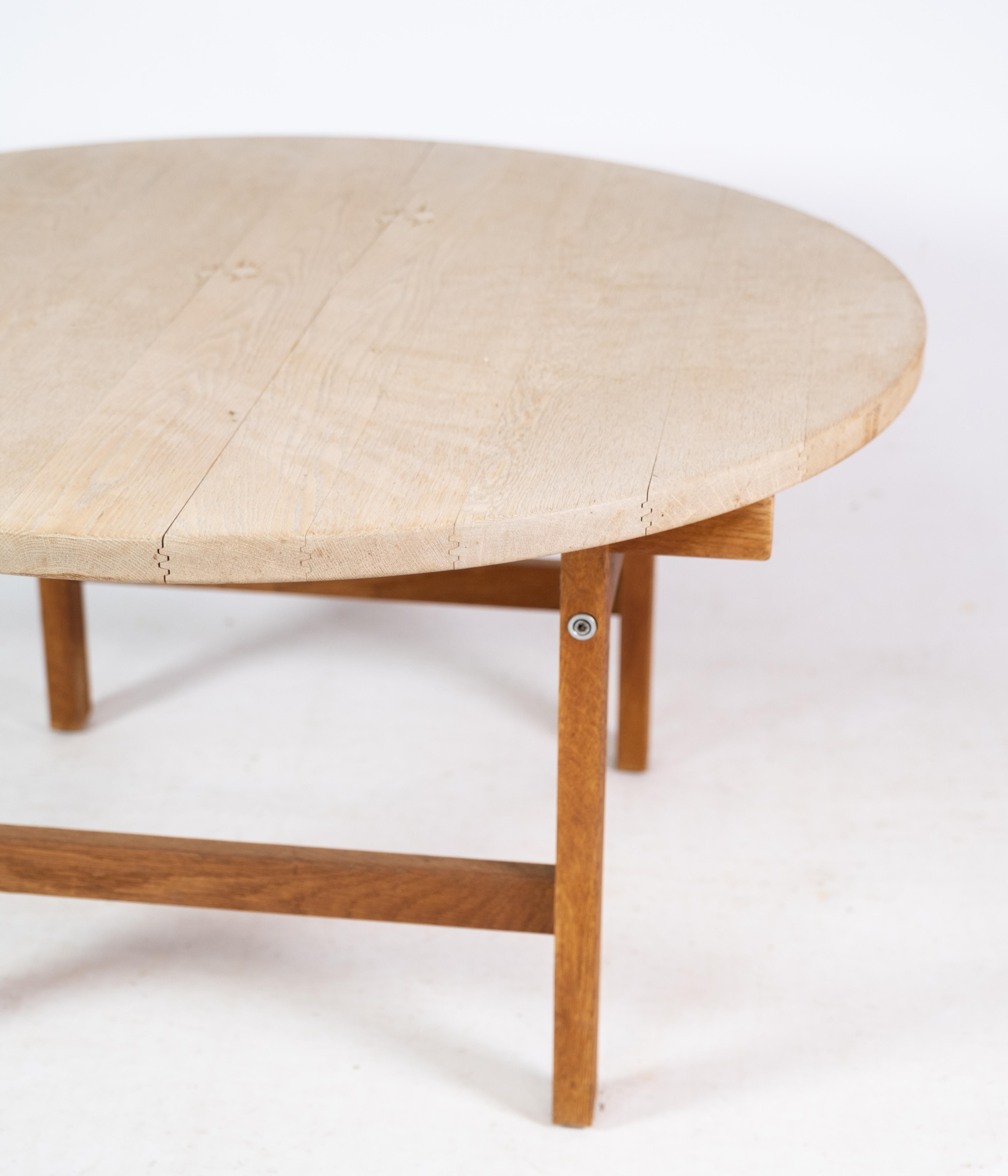This round coffee table, designed by Hans J. Wegner, is a fine example of Danish craftsmanship. Made of solid oak, it was manufactured by PP Møbler, a company renowned for its dedication to quality and traditional woodworking techniques. The table