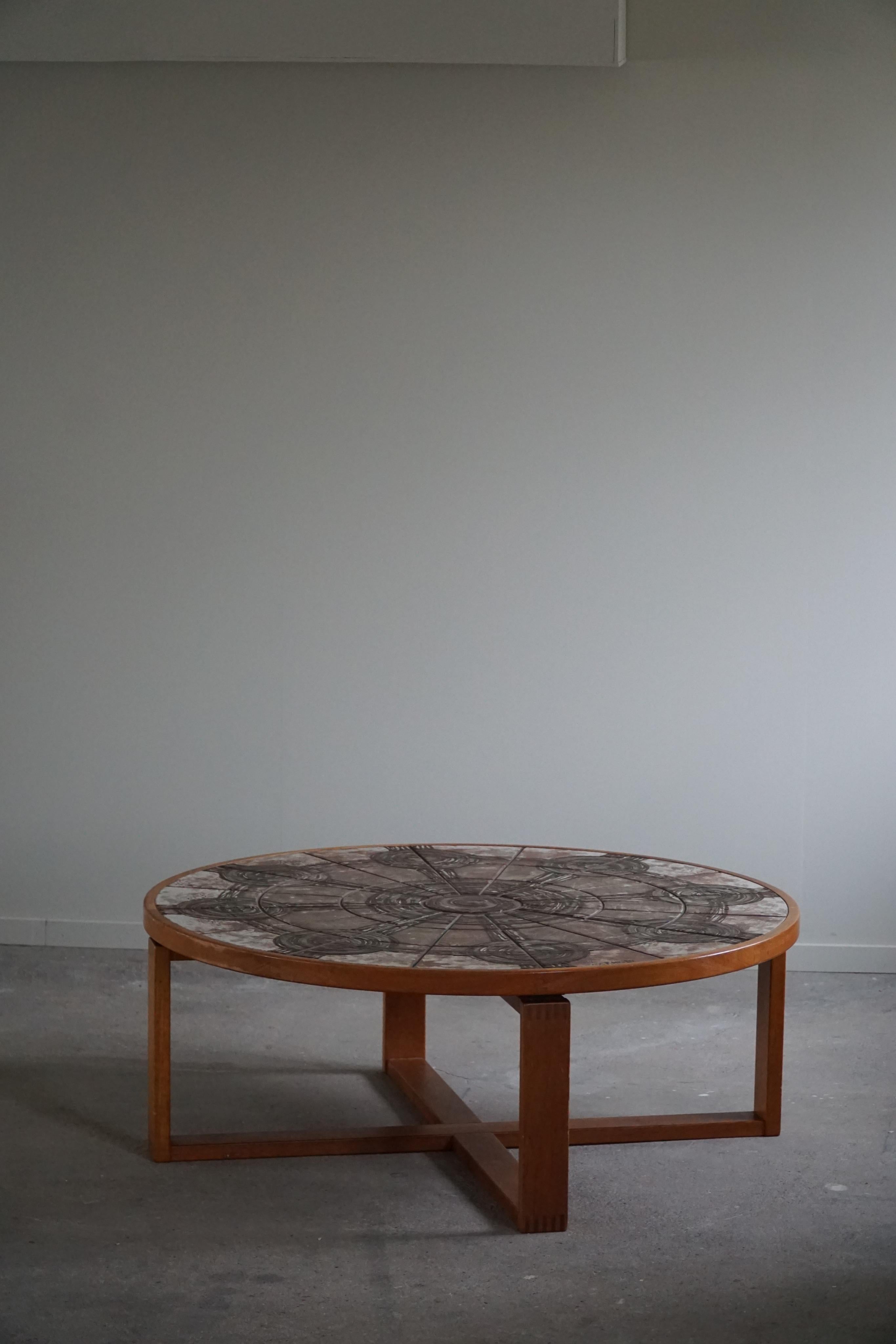 A quality large round coffee table / sofa table in solid teak with handmade ceramic tiles. Designed by Ox Art for Trioh in the 1970s, Denmark. Signed here by.

This lovely table will complement many interior styles. A modern, antique, classic,