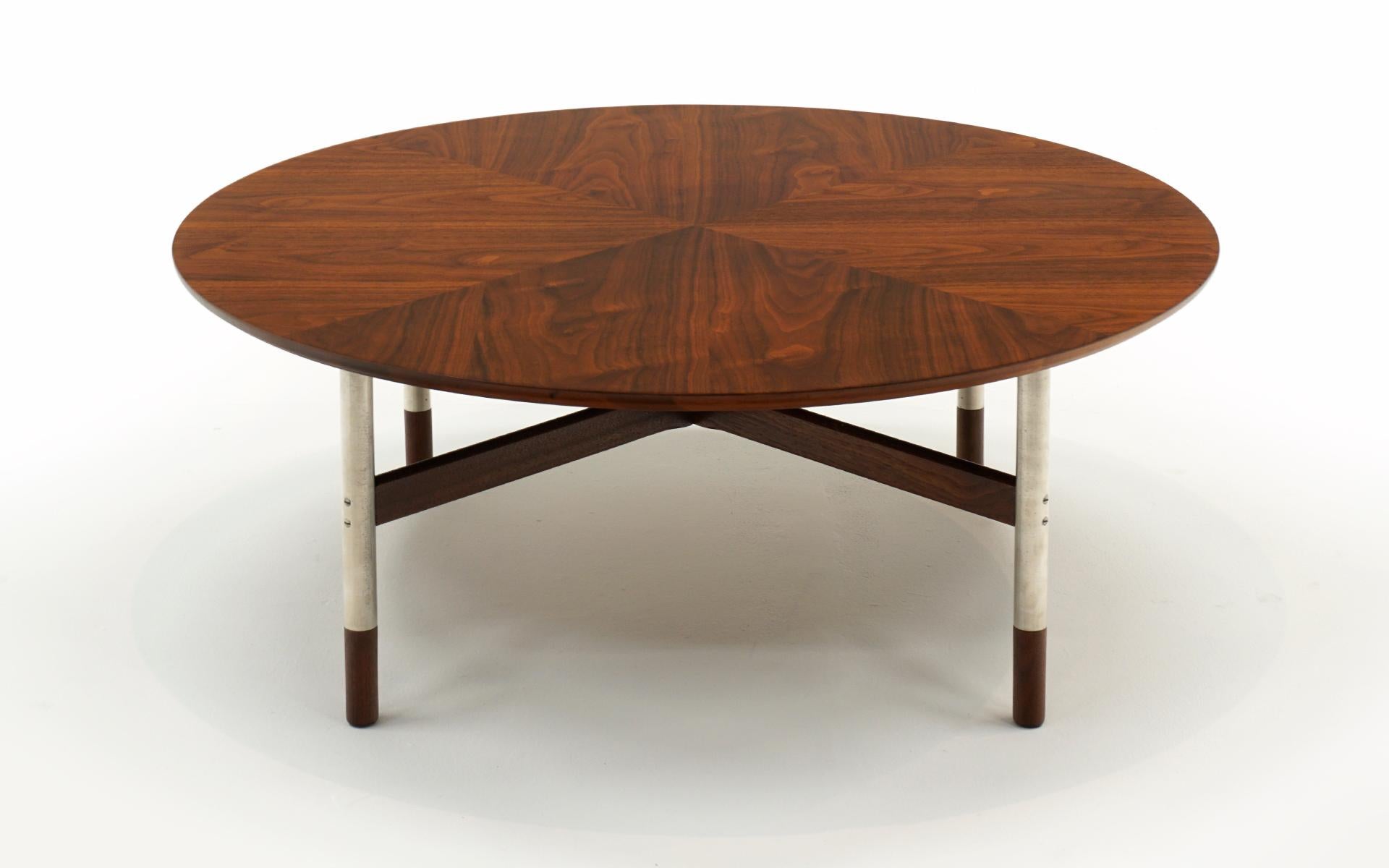 Round walnut coffee table in the style of Finn Juhl or Arne Vodder. The top is supported by Satin Chrome Legs with walnut feet. Expertly refinished and ready to use.