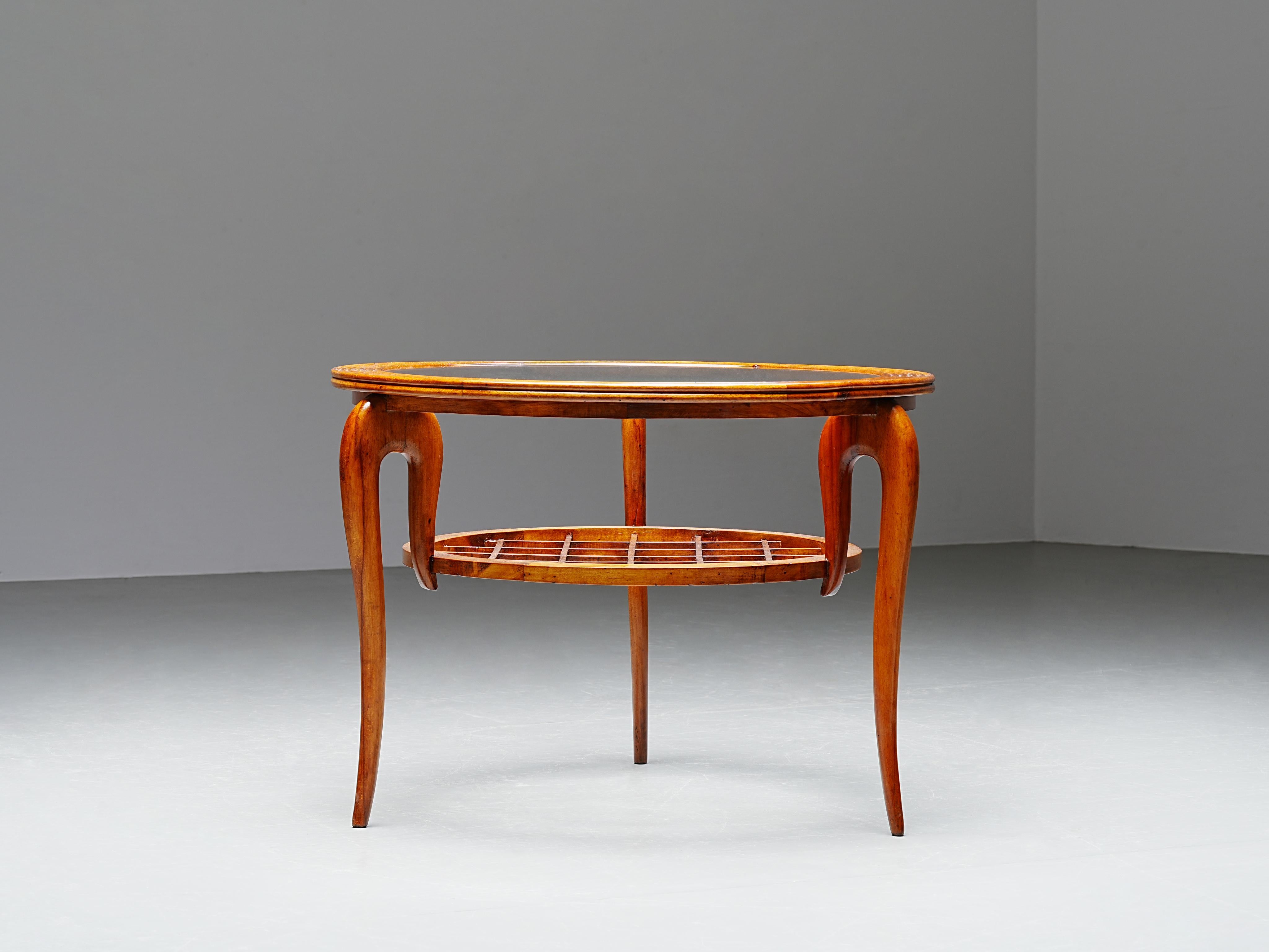 Round Coffee Table in Walnut and Glass, Italy, 1950's

Elegant and expressive 1950's coffee table with a distinctive combination of three textures: a ribbed wooden ring around the glass top, a floating lower shelf with a playful open grid, and