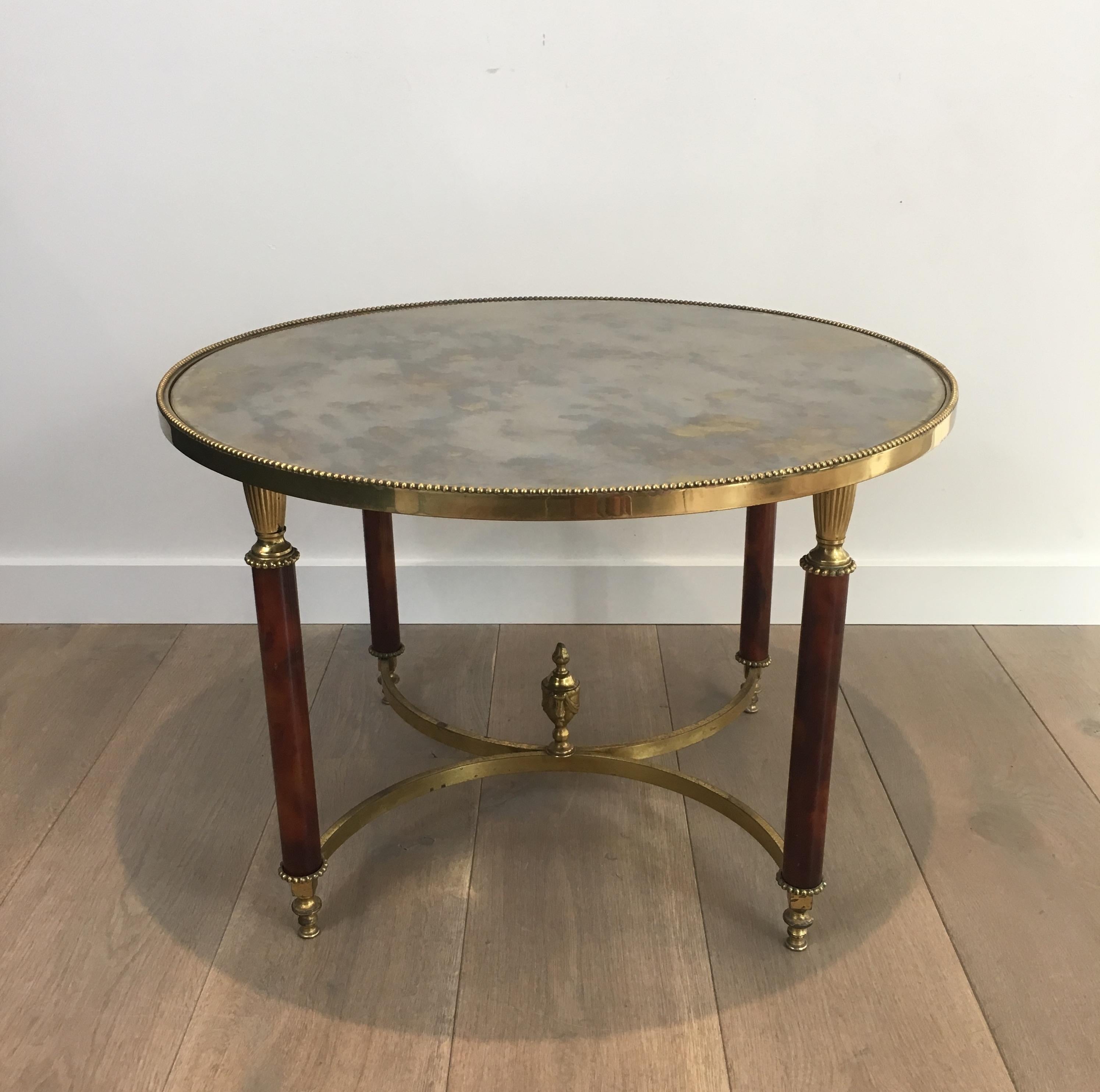 Attributed to Maison Jansen. Round Neoclassical coffee table, side table or end table made of rare red Lucite legs, brass and eglomised mirror top. French, circa 1940.