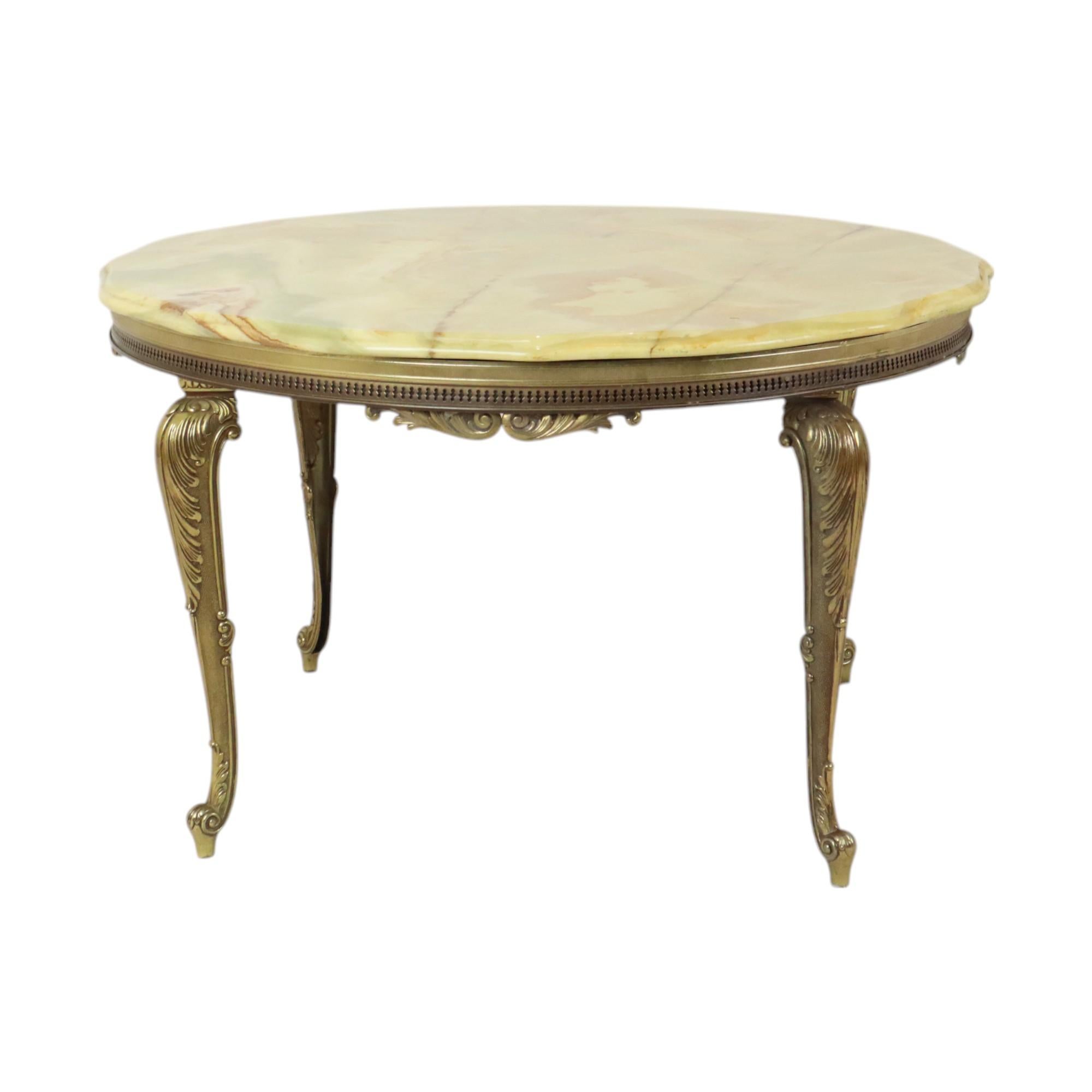 Magnifique table basse ronde de grande qualité avec plateau en marbre onyx et base en laiton Louis Quinze décorée de feuilles d'acanthe et de gracieuses boucles, style Hollywood Regency de la seconde moitié du 20e siècle.

Cette belle table basse