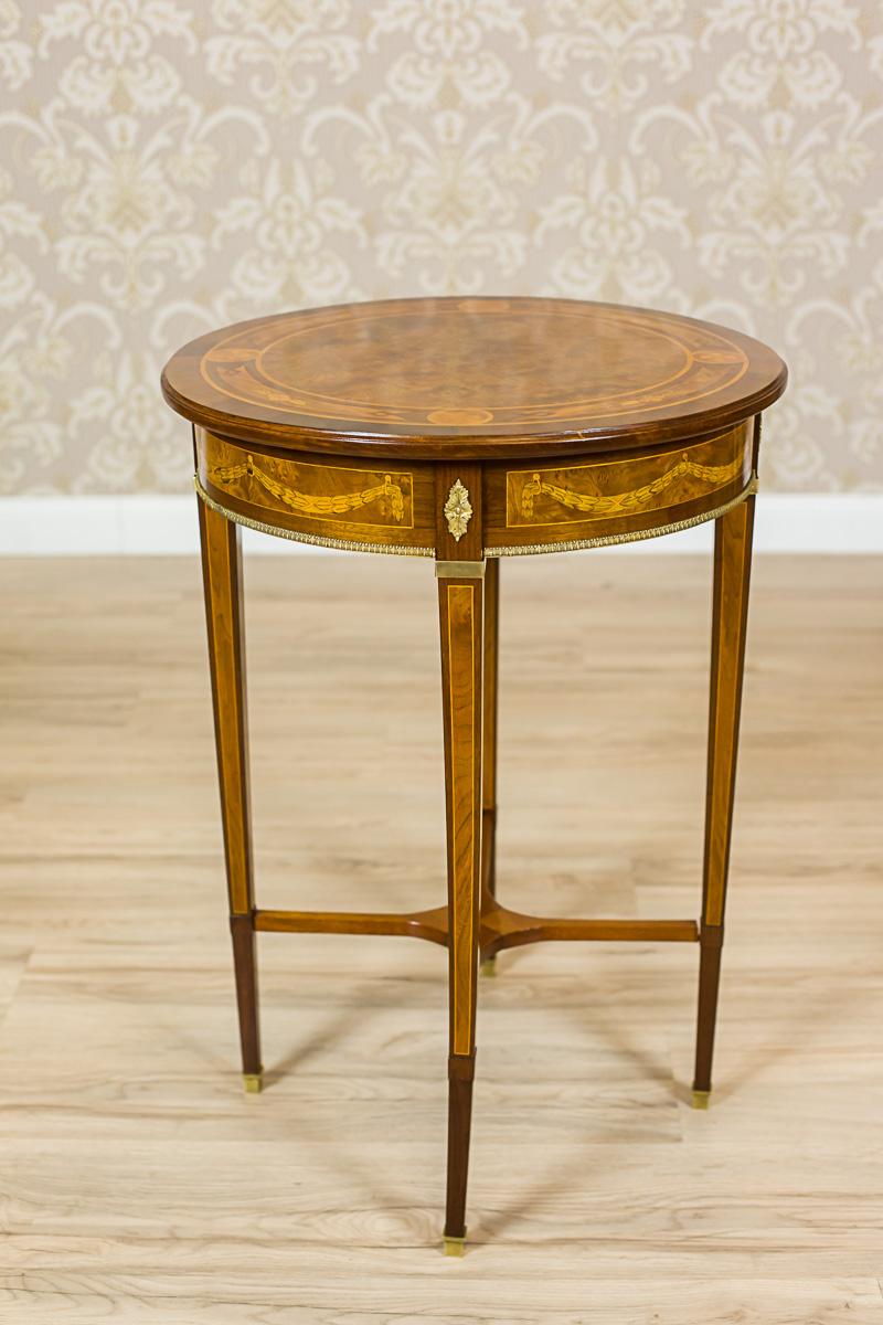 We present you this very decorative, small table, veneered with walnut, from the second half of the 20th century.
The center of the table top with a decorative walnut burl and filet stripes intertwined with an intarsia.
The legs are straight,