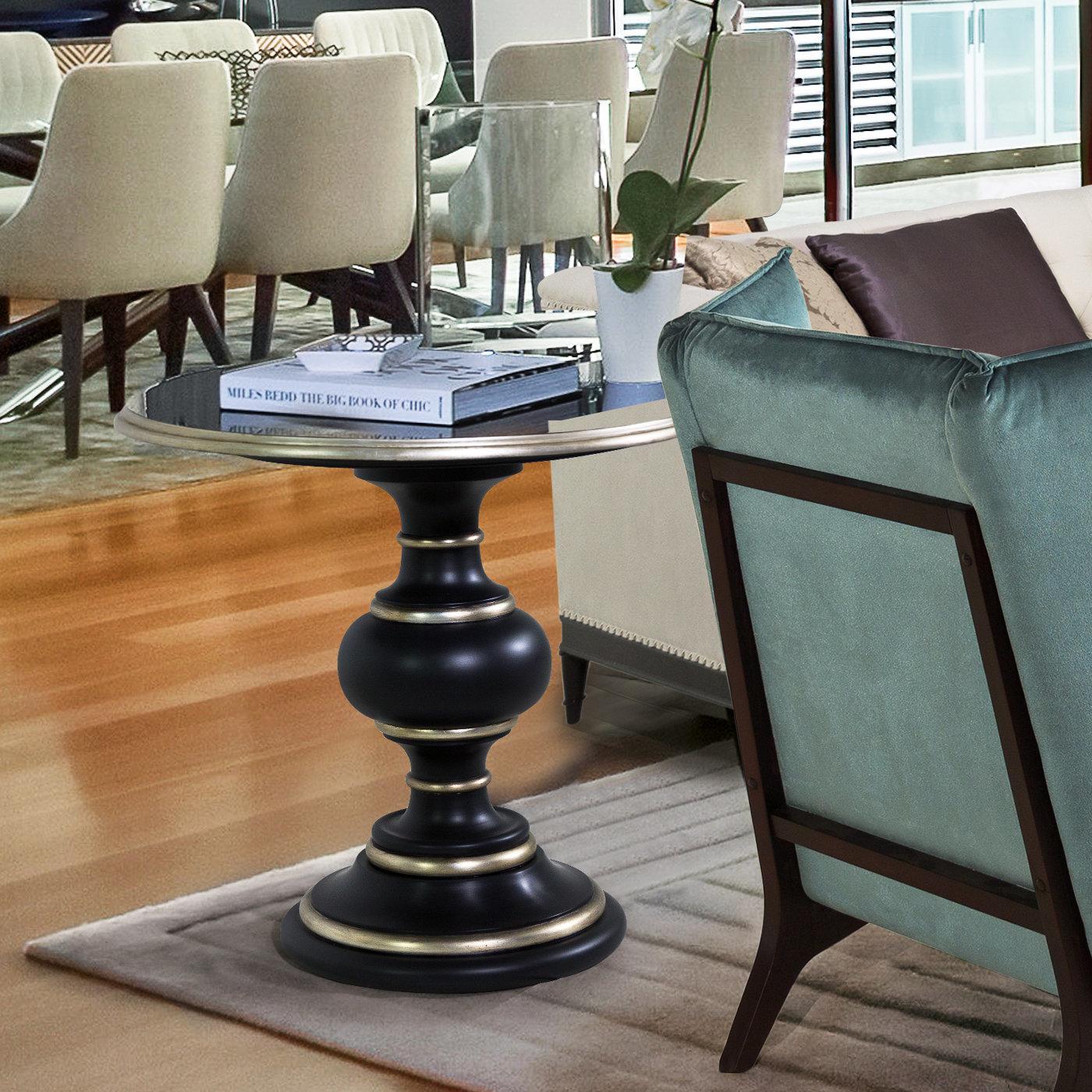 This enthralling coffee table marked by a captivating silhouette will capture the eye in any modern or classic decor with its sculptural and opulent look. The MDF structure stained in glossy colonial black is brightened up by profiles covered in
