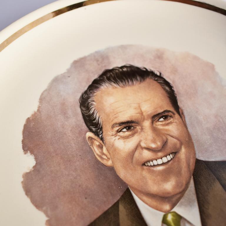 A circular cream round commemorative plate of President Nixon. Reads Richard M. Nixon 37th President. Gold detail around the edges, with the image of President Nixon in the center. 

Richard Milhous Nixon was the 37th president of the United