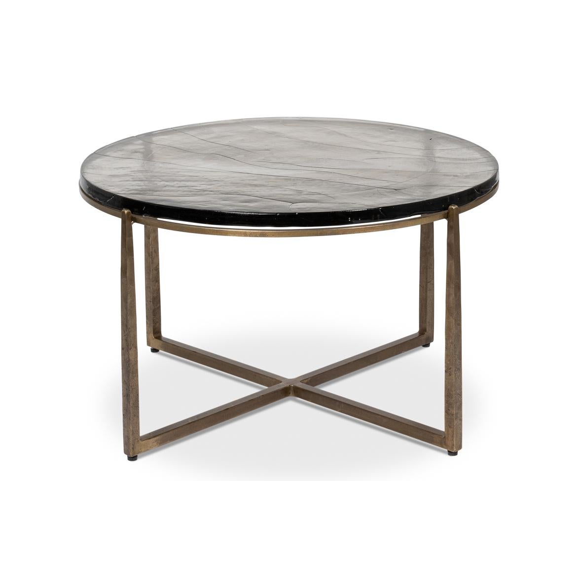 Esta exquisita pieza cuenta con una base de hierro forjado a mano en un acabado de latón envejecido, que le da un toque de elegancia vintage a la vez que mantiene una elegante estética contemporánea. La tapa de cristal fundido, con su textura