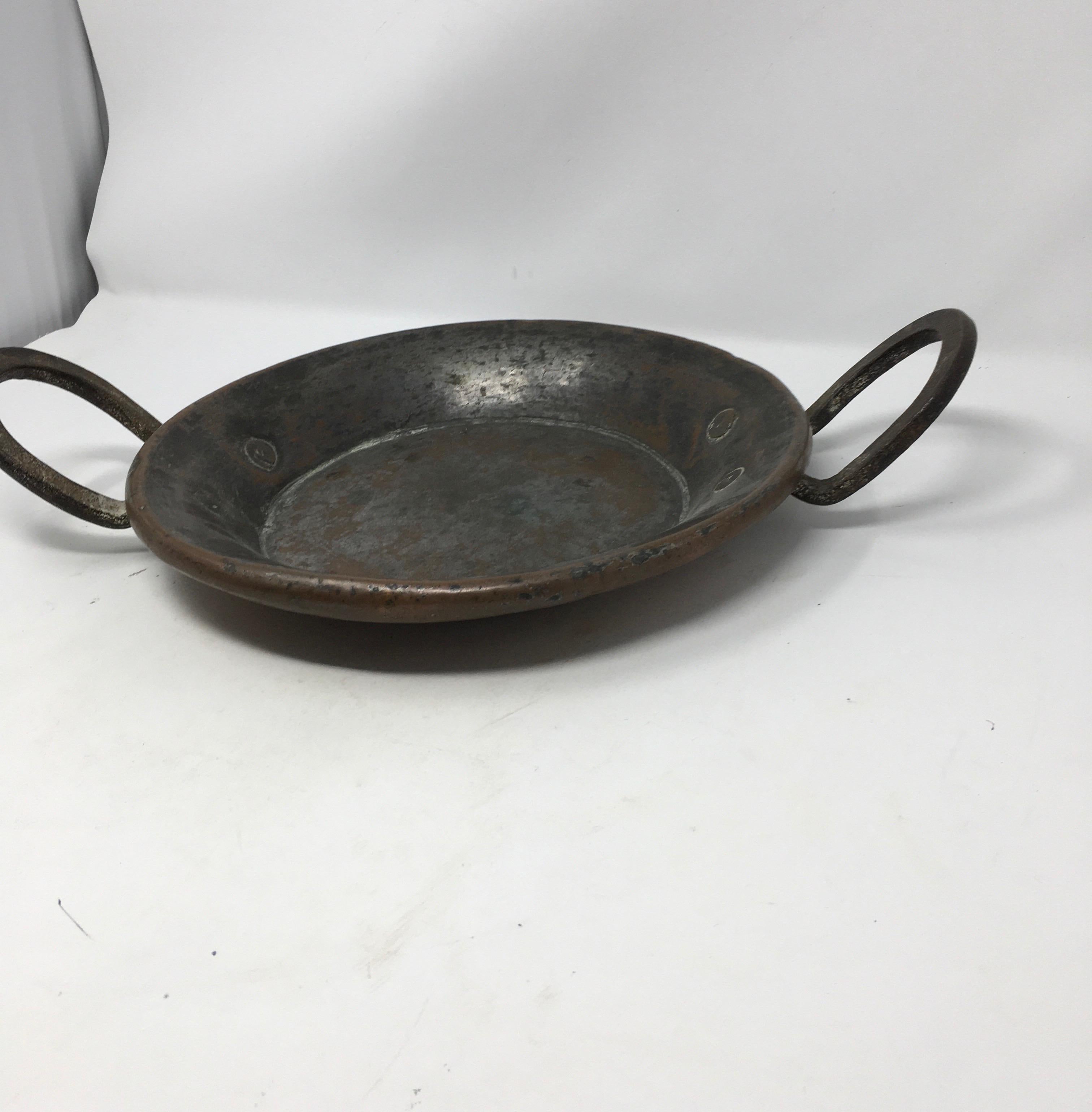 This is an old French copper pot featuring an iron handles and copper rivets. The pot is tin lined but has lost some its tin over many years of use. Boasting a wonderful patina this piece would add provincial charm to your kitchen.
This piece