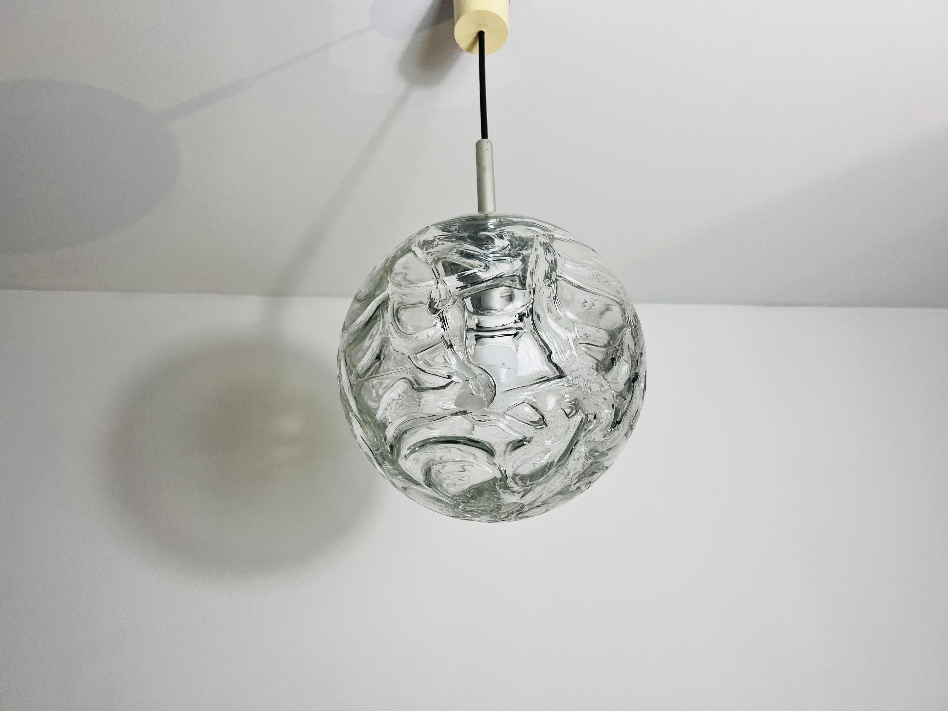 Una splendida lampada a sospensione con ciotola in vetro realizzata in Germania negli anni '70. Questa elegante lampada è caratterizzata da uno squisito vetro di Murano, noto per la sua qualità superiore e per la sua maestria. Il vetro è
