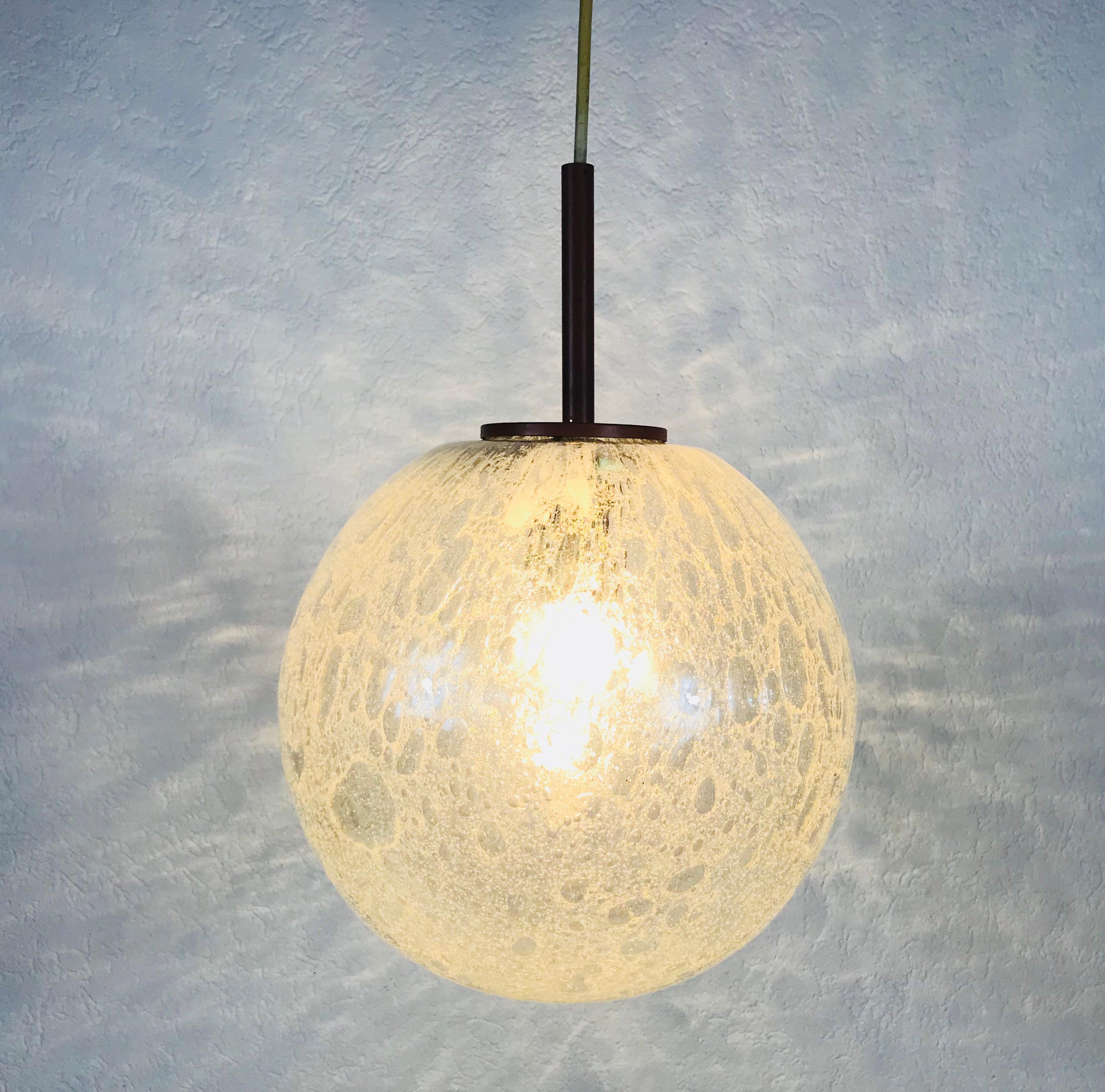 Una bellissima lampada a sospensione con ciotola in vetro realizzata in Germania negli anni Settanta. La lampada è realizzata in vetro di Murano. Ha un incredibile colore trasparente ed è molto solido. La parte superiore della lampada è in metallo