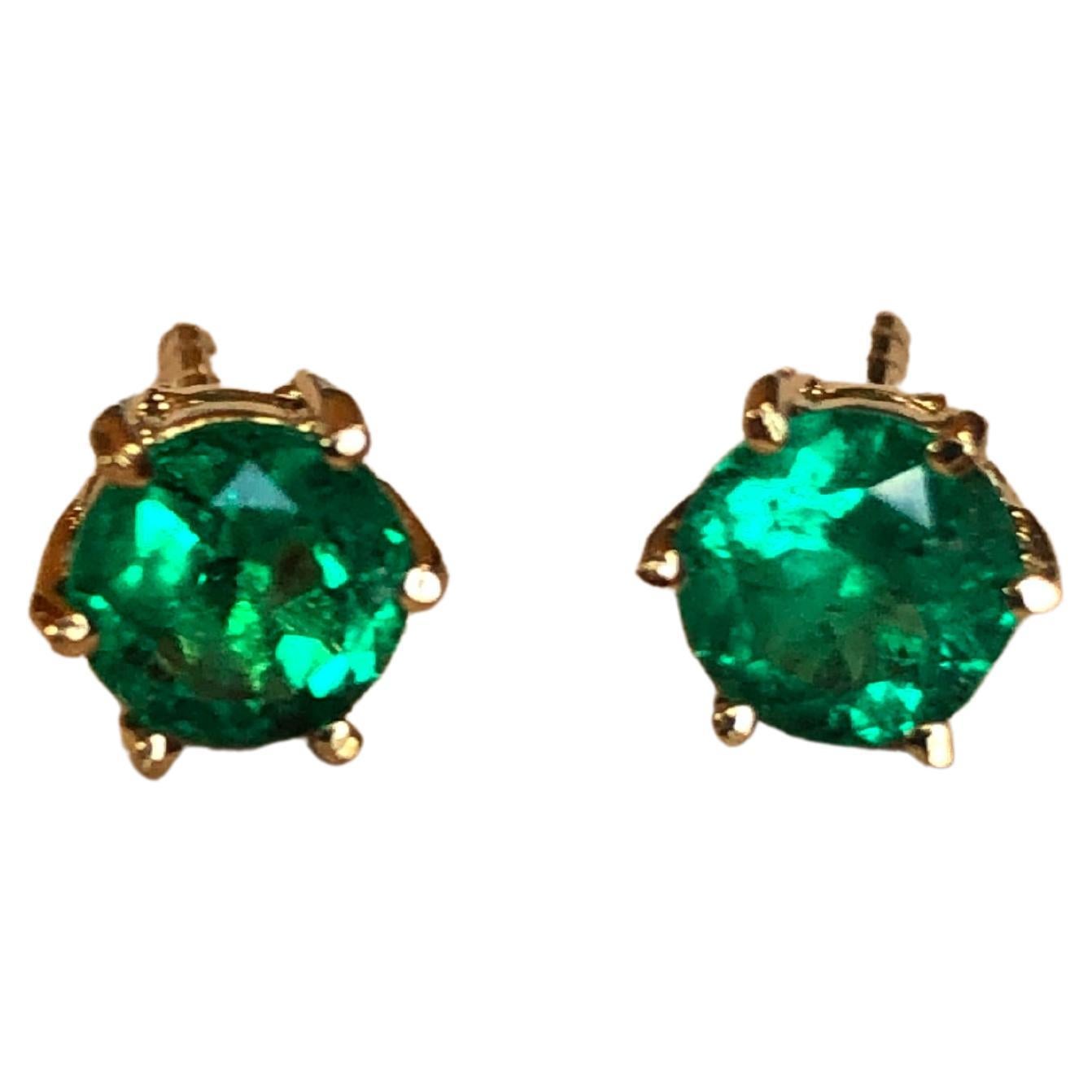 A beautiful fine pair of round-cut AAA natural emerald stud earrings set in 18k yellow gold.  Each earring solely features a sparkly green-colored round cut natural Colombian emerald, which is a 6-prong set open back setting.  The earrings measure