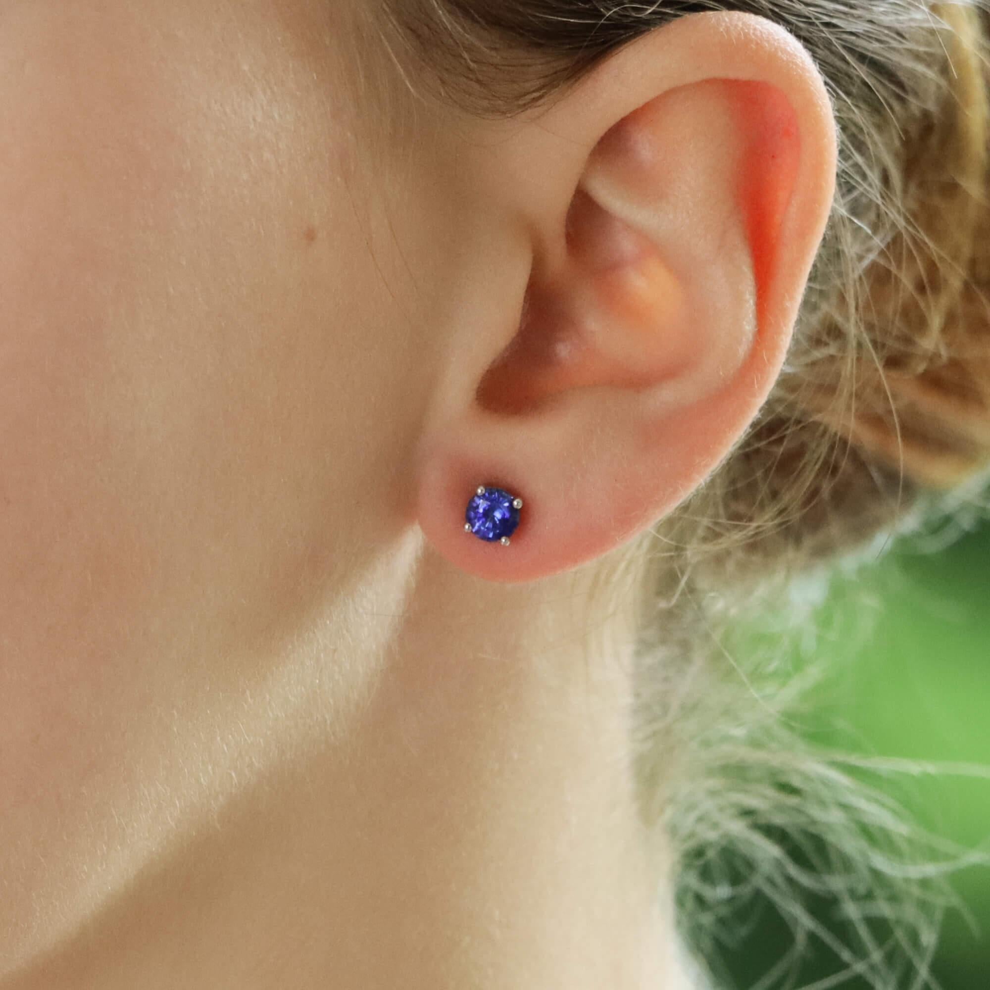 Une belle paire de boucles d'oreilles en or blanc et jaune 18 carats avec des saphirs de taille ronde.

Chaque boucle d'oreille est ornée d'un saphir rond de couleur bleue, serti de quatre griffes au centre. Chaque clou est fixé dans une monture