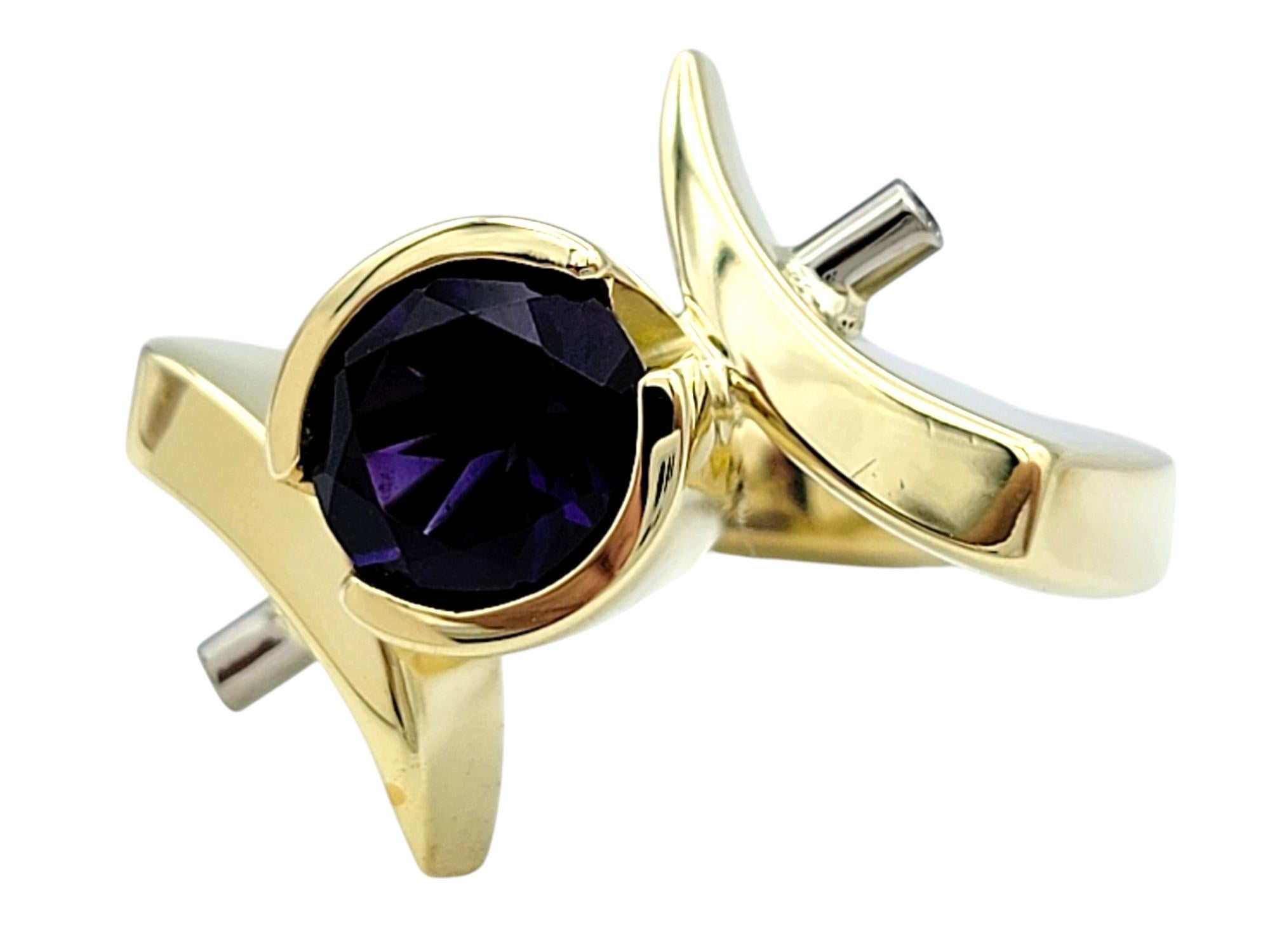 Ring Size: 7

Unveiling a design that is as bold as it is elegant, this contemporary yellow gold amethyst and diamond ring features exquisite white gold posts on either side of the central gemstone. Each post is adorned with a bezel-set diamond at