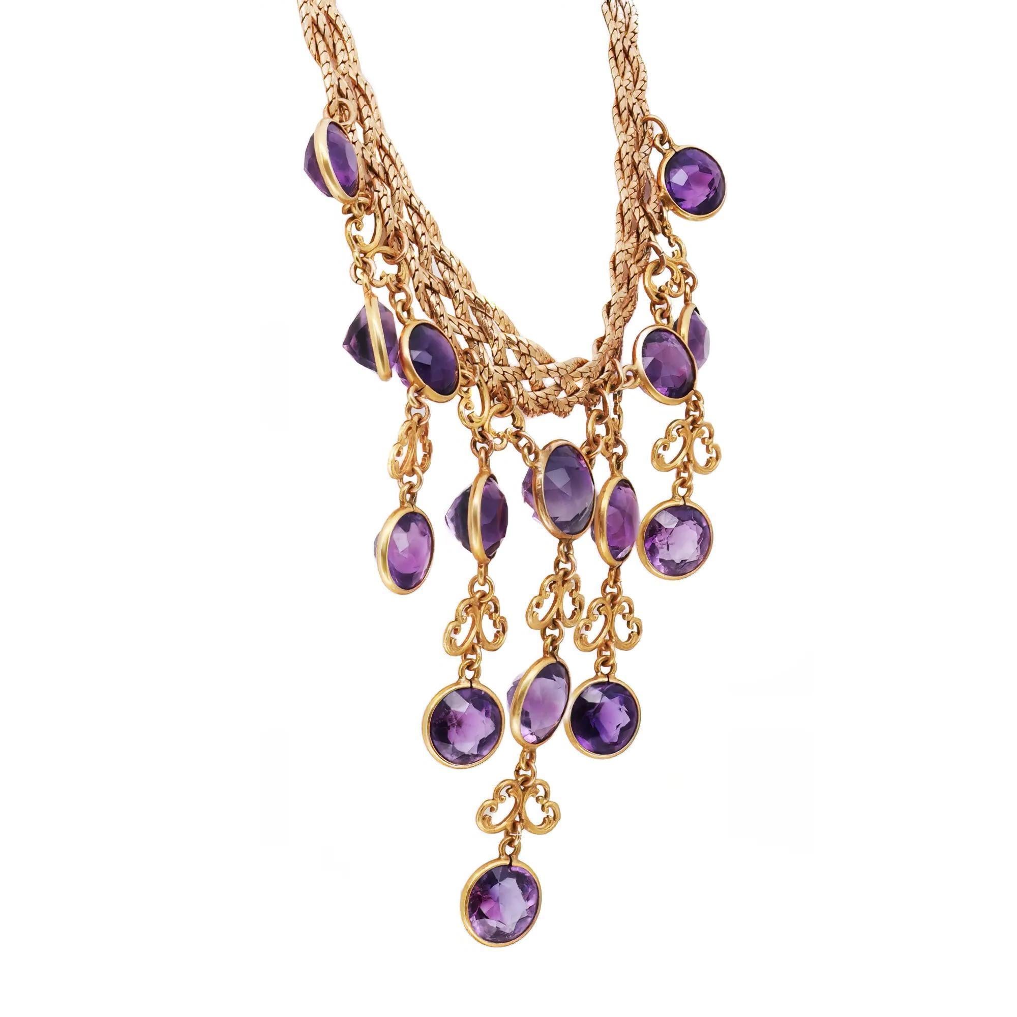 Splendida e trendy collana con pietre preziose. Realizzata in oro giallo 14 carati, questa collana presenta 15 gemme ametiste incastonate a castone con motivi a farfalla in oro, fissate a una catena piatta intrecciata. Lunghezza della catena: 15