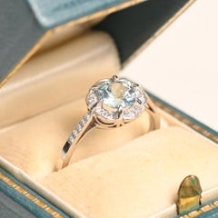 Verlobungsring mit einem Aquamarin von 0.70 Karat. Halo-Ring mit altem europäischem Diamanten aus Platin