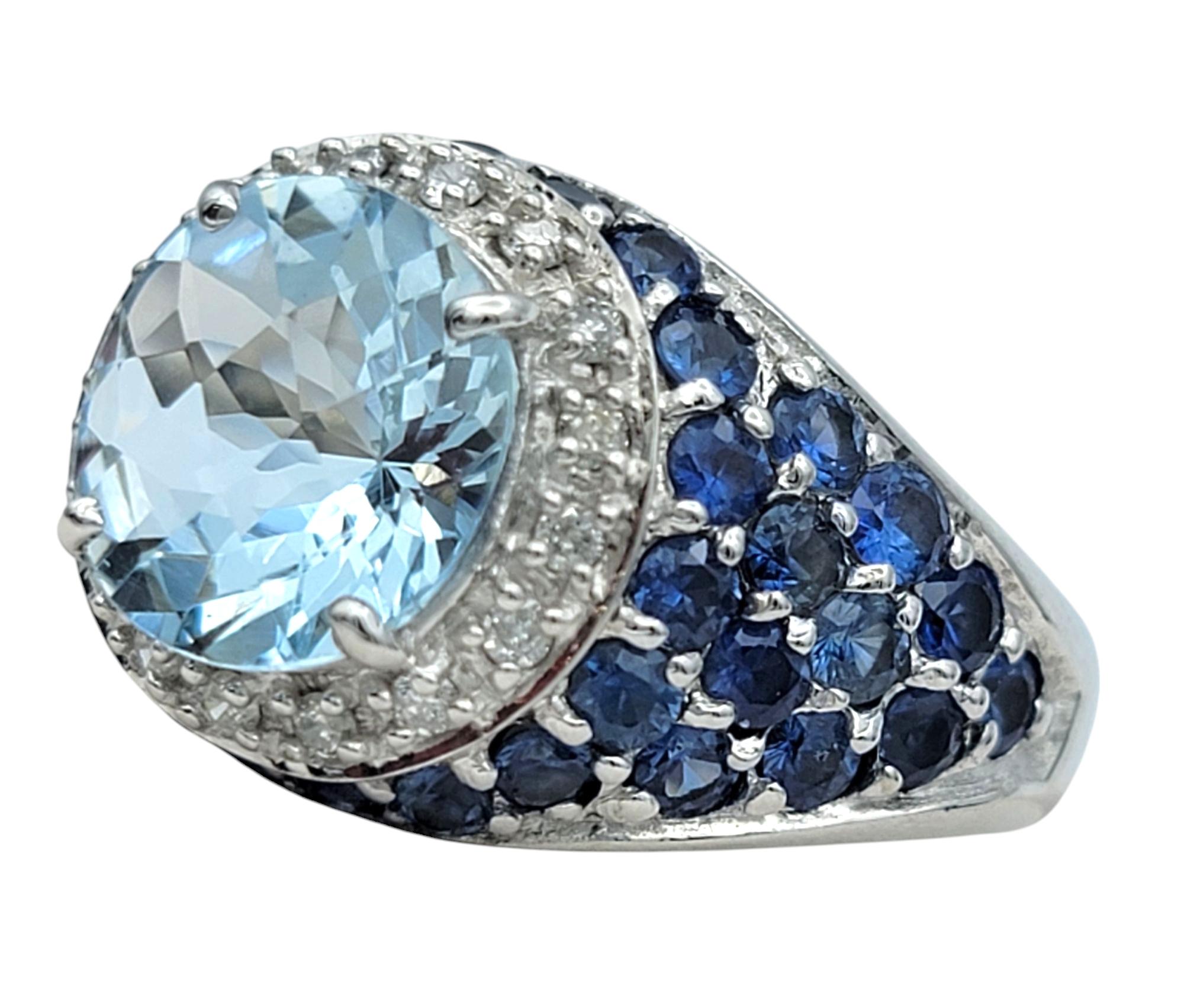 Ring Size: 5

This breathtaking domed ring is a masterpiece of elegance, featuring a mesmerizing round-cut aquamarine at its center. The light blue gemstone exudes a serene and luminous glow, beautifully framed by a dazzling halo of sparkling