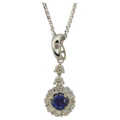 Collier pendentif en or blanc 18 carats avec saphir bleu de taille ronde et halo de diamants