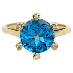 Round Cut Blue Topaz Solitaire Ring with Diamond Heart Prongs in 14K Yellow Gold
