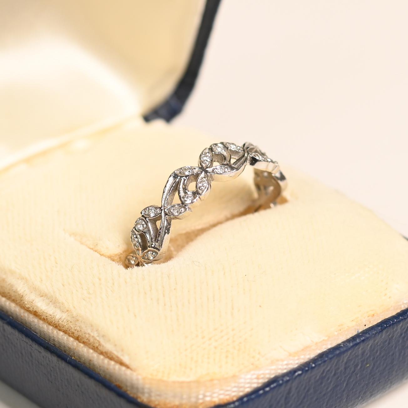 Cette exquise alliance en diamant à motif floral est un véritable témoignage d'élégance intemporelle et de savoir-faire artisanal. Méticuleusement conçu en platine luxueux, le bracelet présente un délicat arrangement de diamants ronds scintillants,