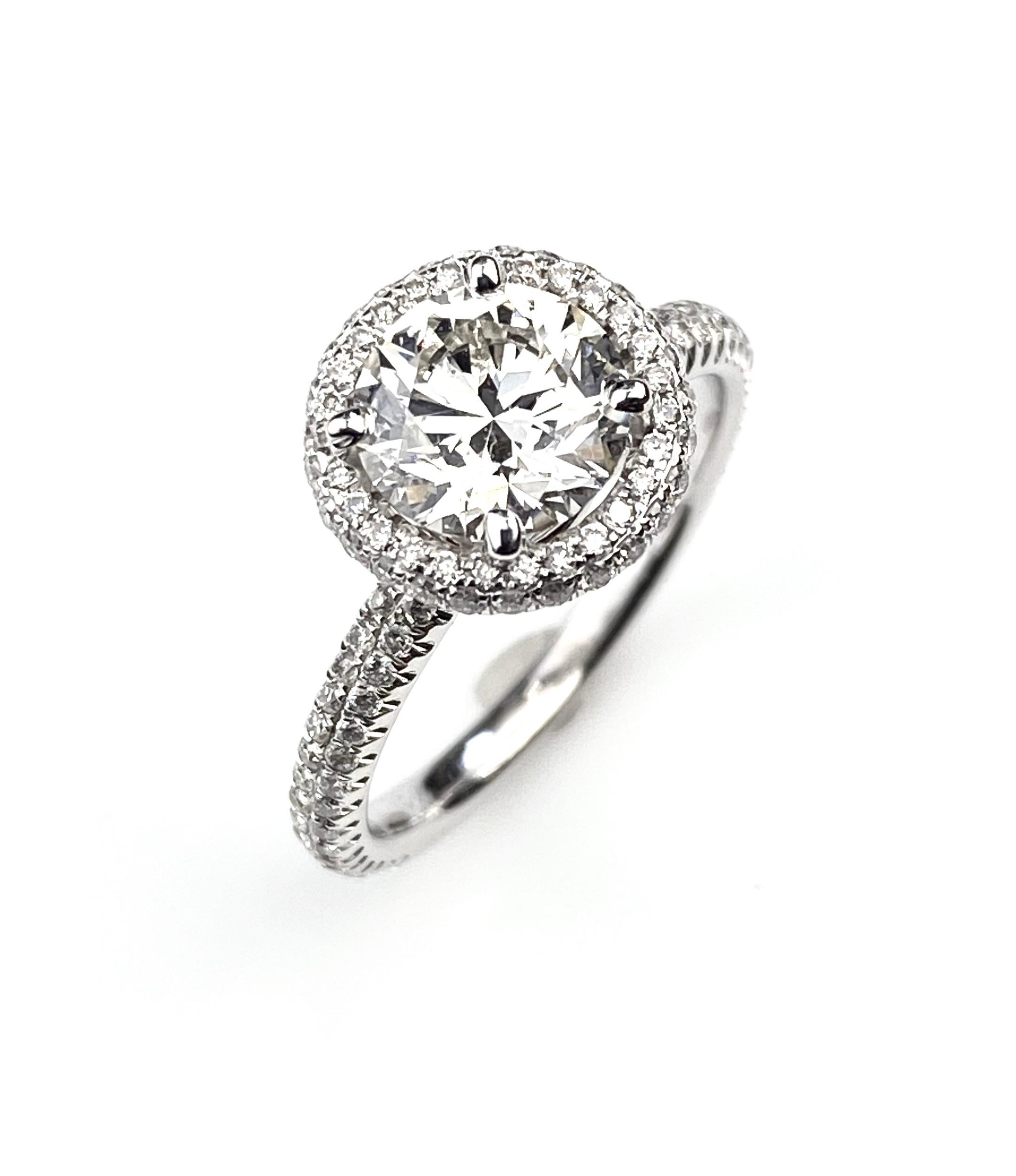 Ladies' round halo engagement ring in 18kt white gold, set with GIA graded 1.52 I SI1, GIA number 2117810529, brilliant round cut diamond. Surrounded by 0.56ct of micro-pave' set diamonds, 7/8 eternity. Side diamonds are F/G colour and VS/SI1