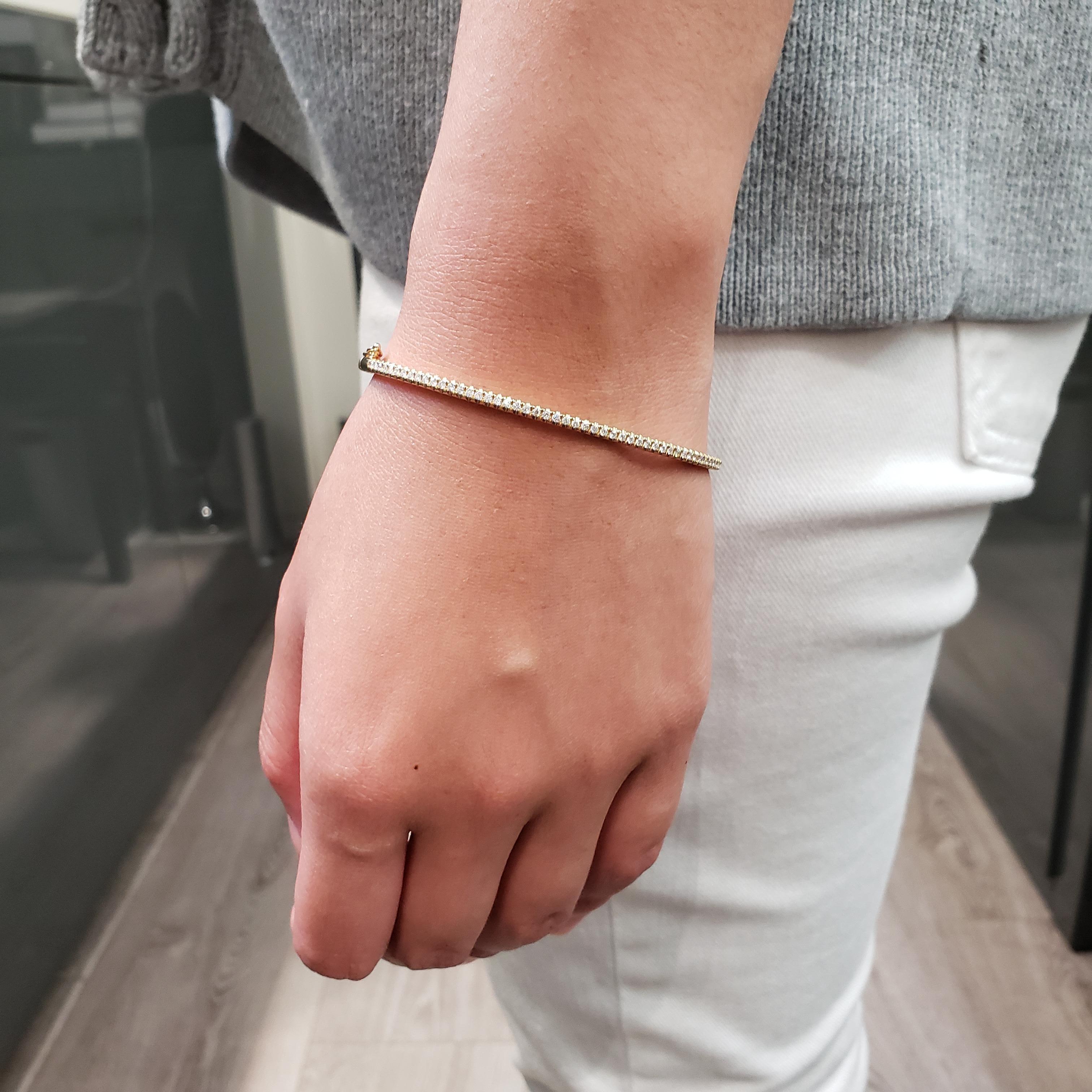 A simple but elegant bangle bracelet set with 51 round cut diamonds weighing 0.50 carats total. Has a clasp to slip and wear the bangle securely. Made in 14k yellow gold. 

Style available in different price ranges. Prices are based on your