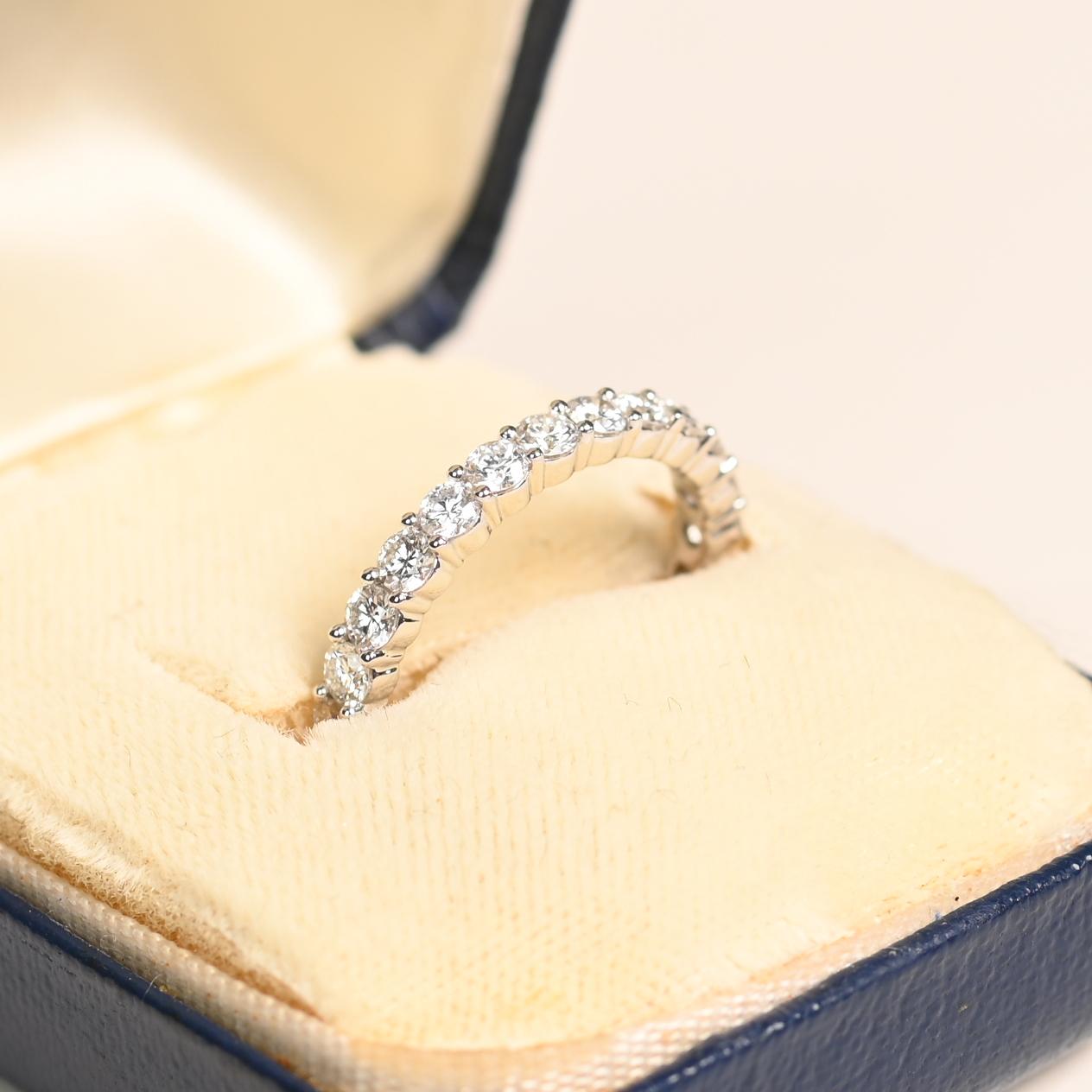 Questa splendida fascia per l'eternità in platino e diamanti è un pezzo senza tempo, perfetto per ogni occasione. Presenta circa 1,5 carati di diamanti di alta qualità, con una gradazione di colore H e di purezza VS1-VS2, che offrono uno squisito