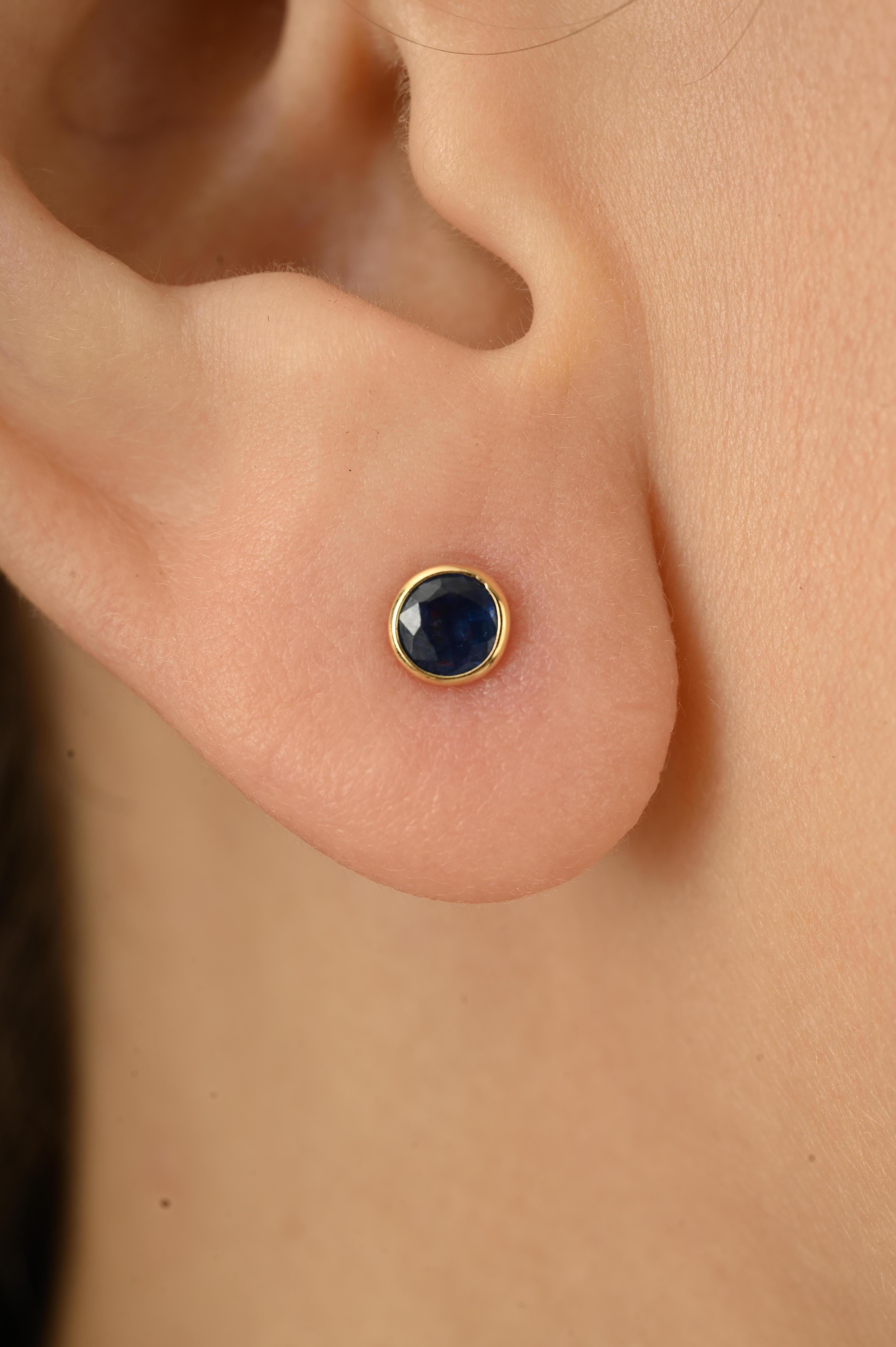 Ces él�égantes boucles d'oreilles sont ornées de saphirs bleus naturels de taille ronde, d'un poids total de 0,3 carat. Les saphirs sont solidement sertis dans de l'or jaune 14 carats, ce qui leur confère un aspect élégant et moderne. Ils sont légers