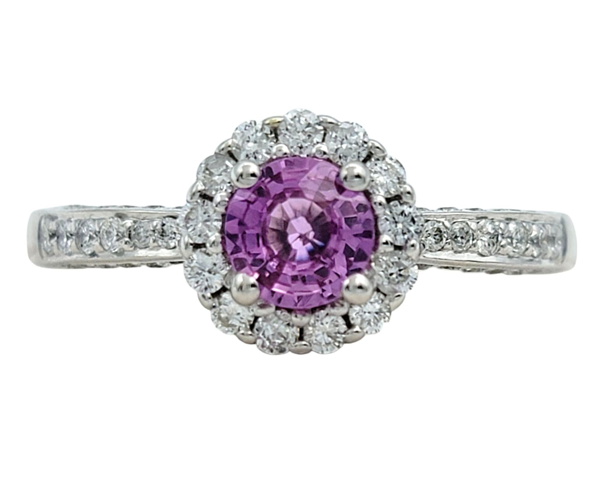 Ring Size: 8

This sapphire and diamond ring brings a delicate and timeless elegance. At its center is a pink round-cut sapphire framed in a classic diamond halo that enhances the soft hue with brilliant contrast. The diamonds continue down the