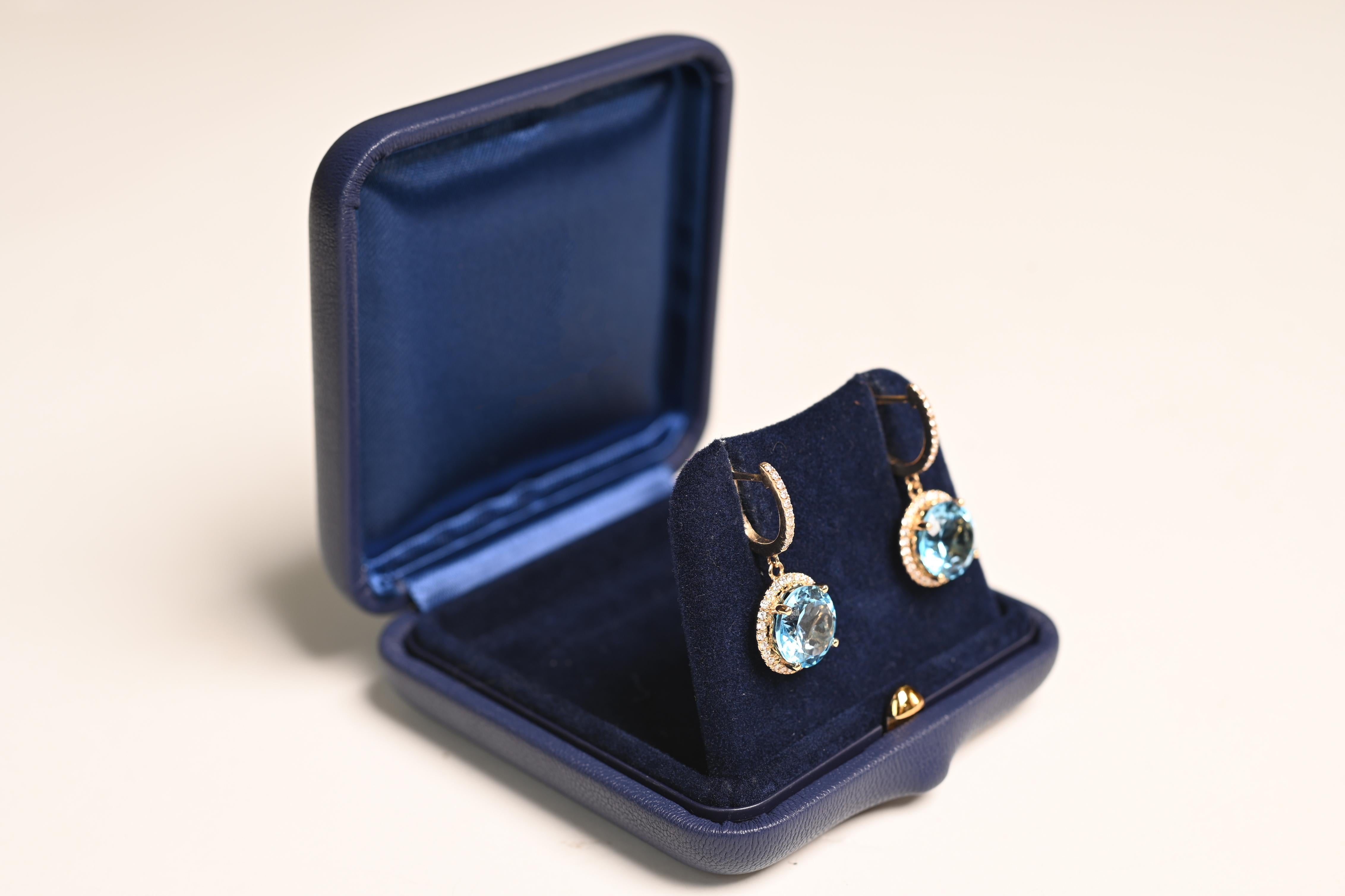 Ces boucles d'oreilles exquises témoignent d'un savoir-faire raffiné et d'une élégance intemporelle. Au centre, deux superbes topazes rondes d'environ 6,10 carats sont serties pour mettre en valeur leur couleur vibrante et leur éclat. Les pierres de