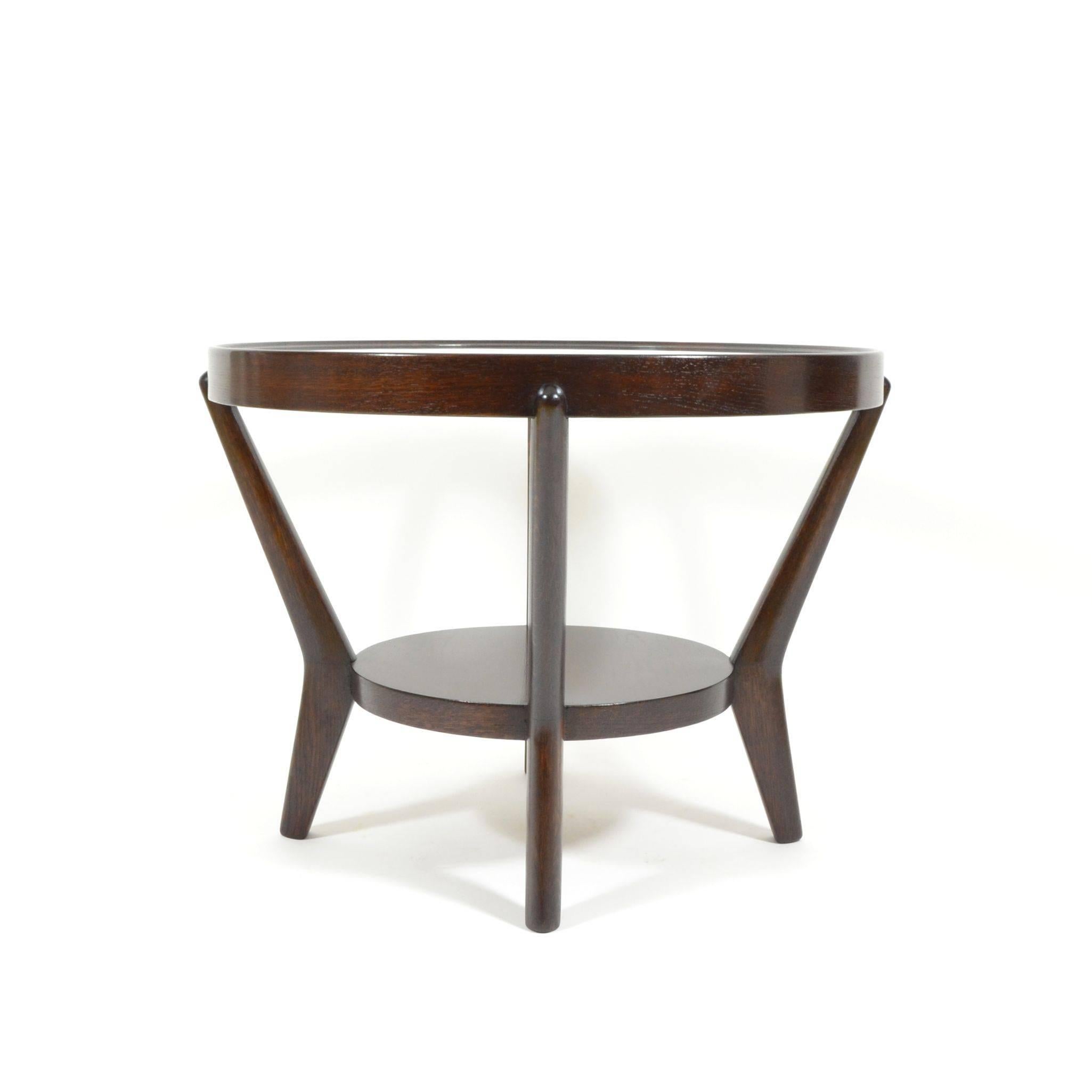 Round coffee table in functionalist style, designed in 1944 by K. Koželka and A. Kropácek for Ceské Umelecké Dílny. Varnished veneer, round glass table top inserted into a wooden frame. This table comes from a seating group that won a silver medal