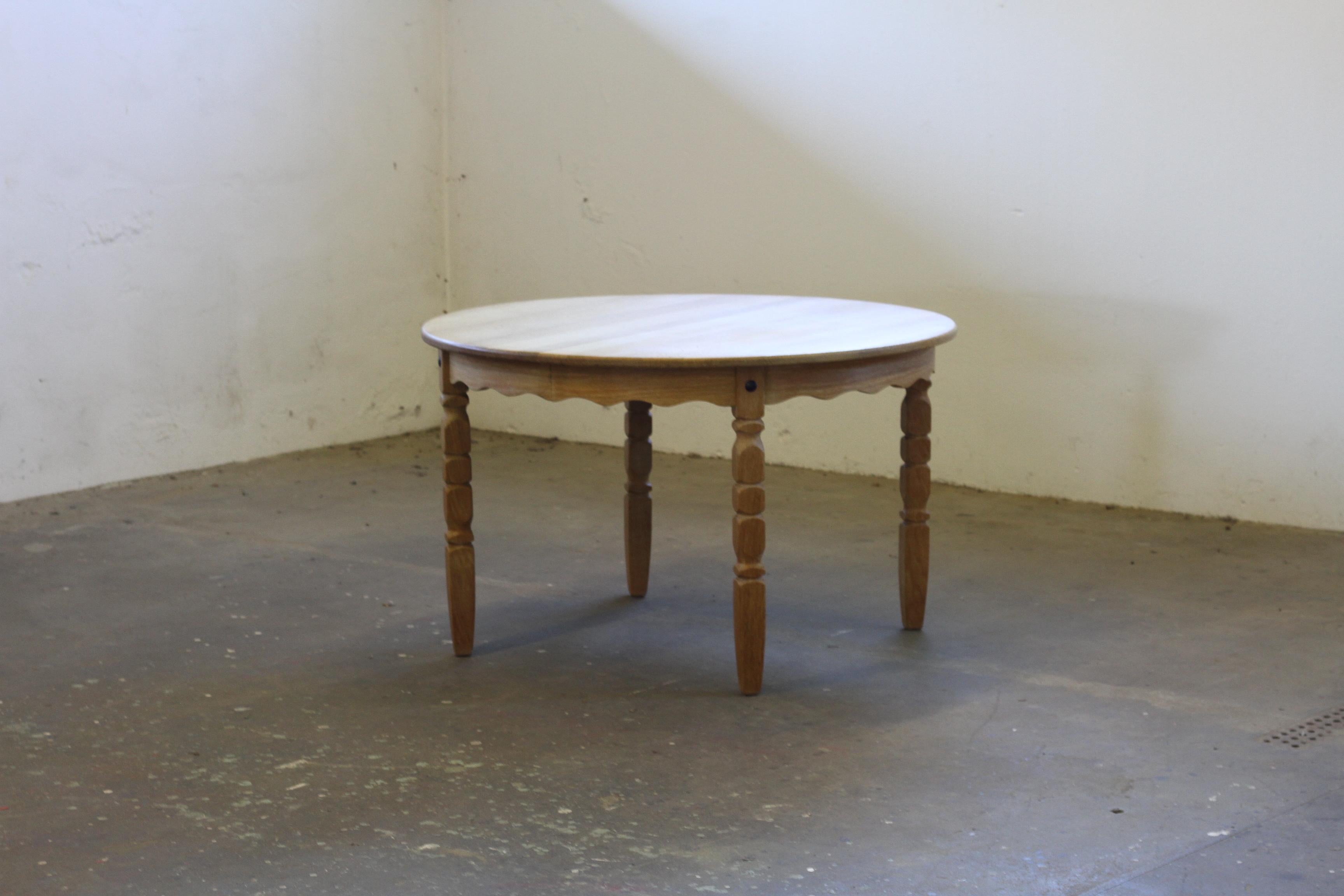 This vintage mid-century oak dining room, or kitchen, table captures the essence of Henning Kjærnulf's design philosophy, blending a bold brutalist aesthetic with refined danish craftsmanship. The intricate leg carvings harmonize beautifully with
