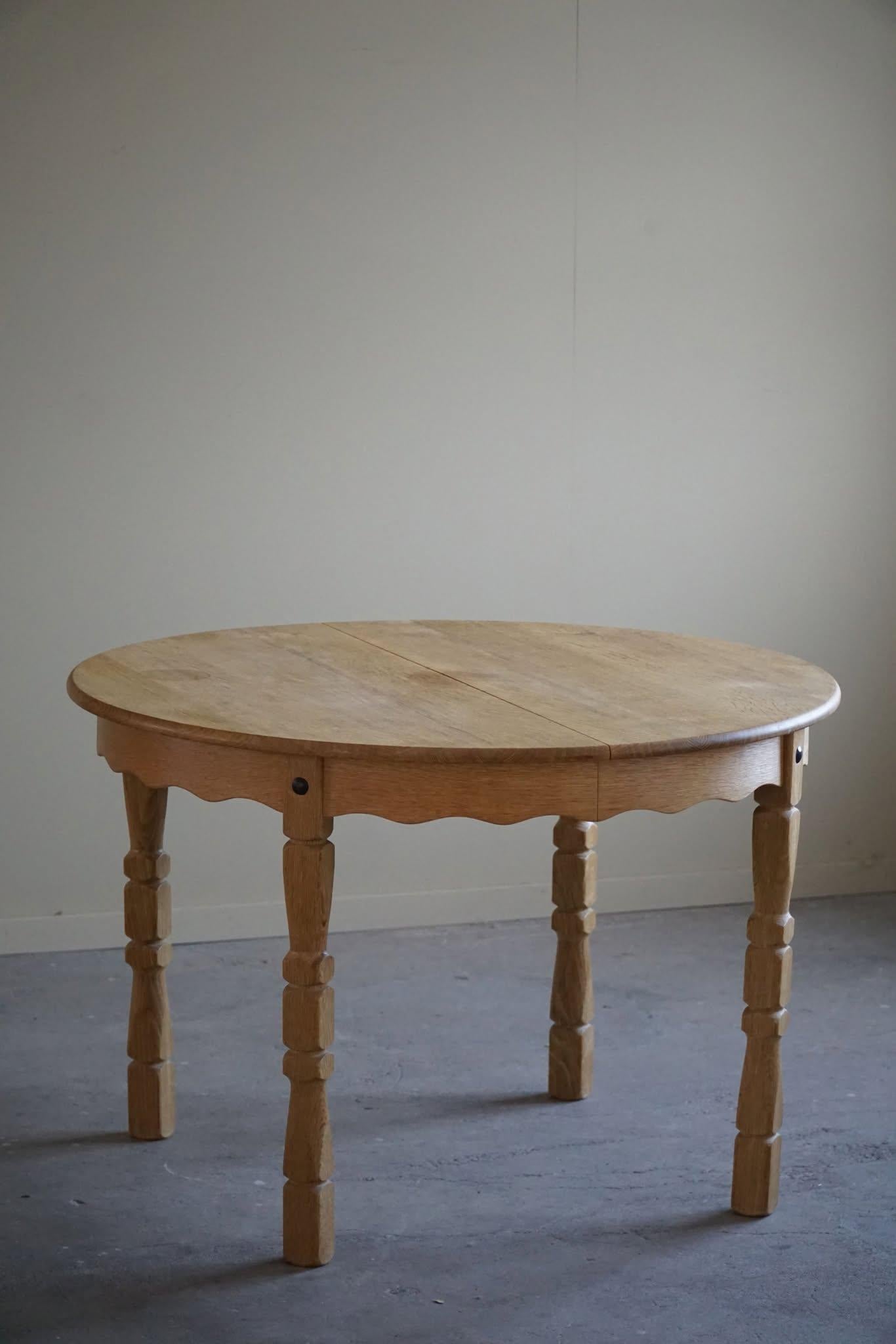 Mesa de comedor redonda clásica de roble macizo con dos extensiones, fabricada en los años 60 por un ebanista danés. Una figura escultural para el interior moderno.

Patas curvadas y gran artesanía en esta mesa brutalista.
Algunas marcas en la