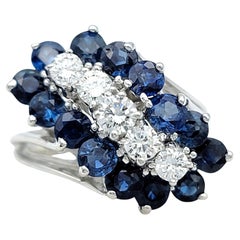 Anello con diamante rotondo e zaffiro blu con motivo a grappolo diagonale in oro bianco 14 carati